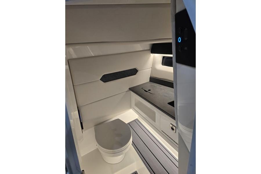 2026 Cobalt R31 boat interior with modern bathroom, featuring sleek design and efficient layout.