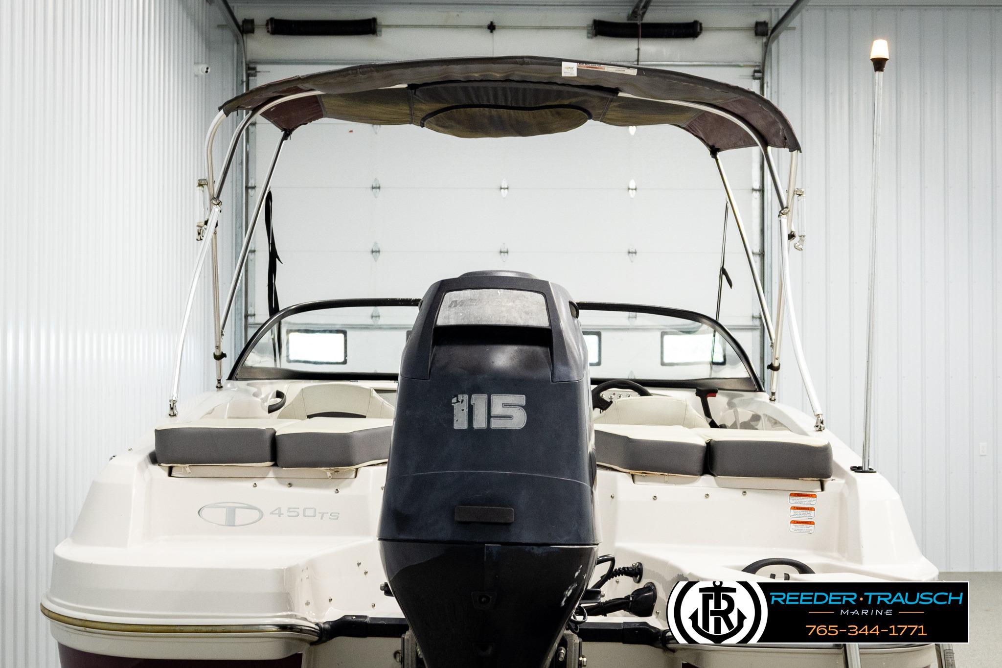 2016 Tahoe 450 TS boat with outboard motor in a garage setting.