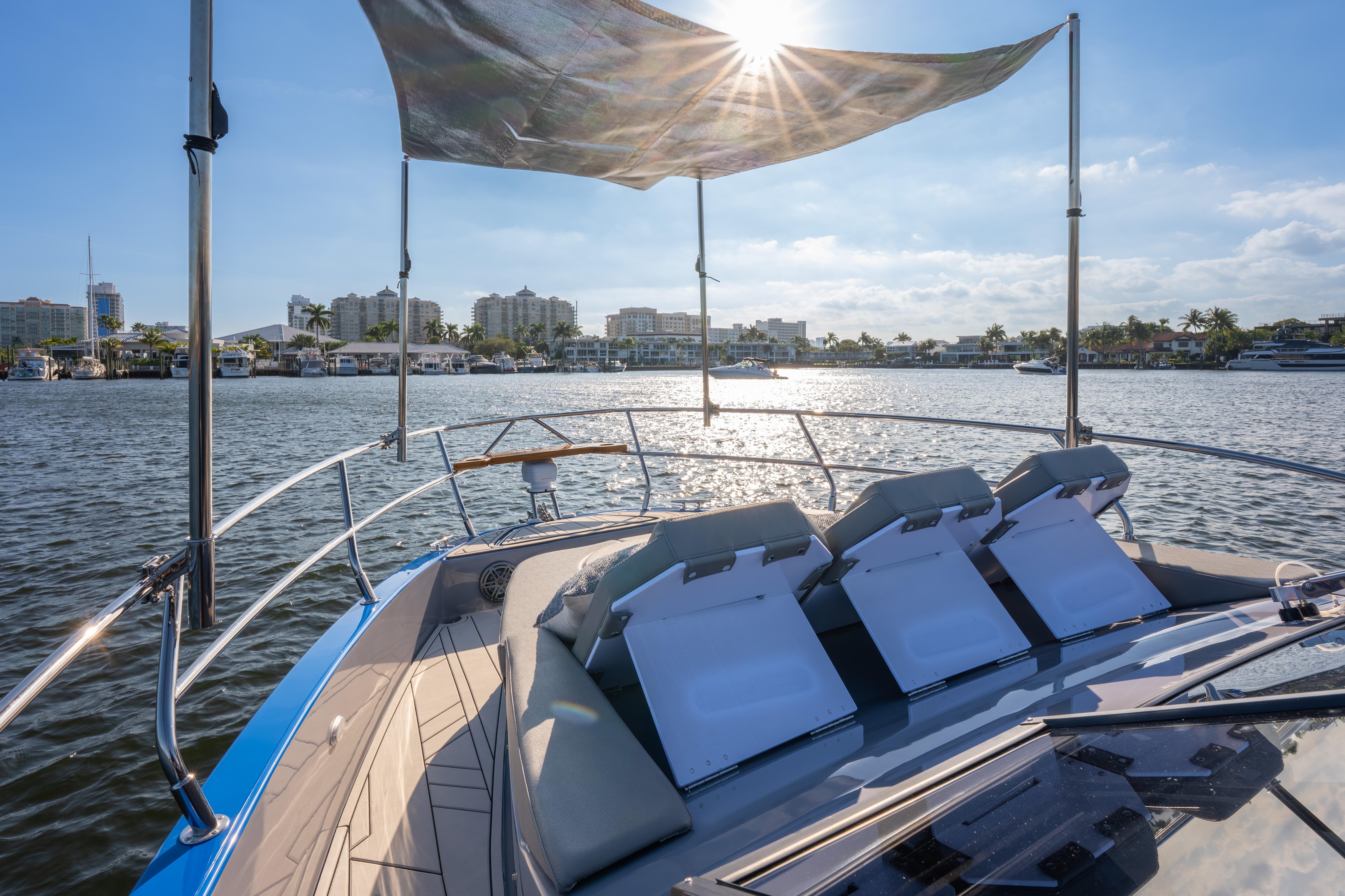 Luxurious Hanover 347 yacht, 2026 model, cruising on a sunny waterfront with city skyline.