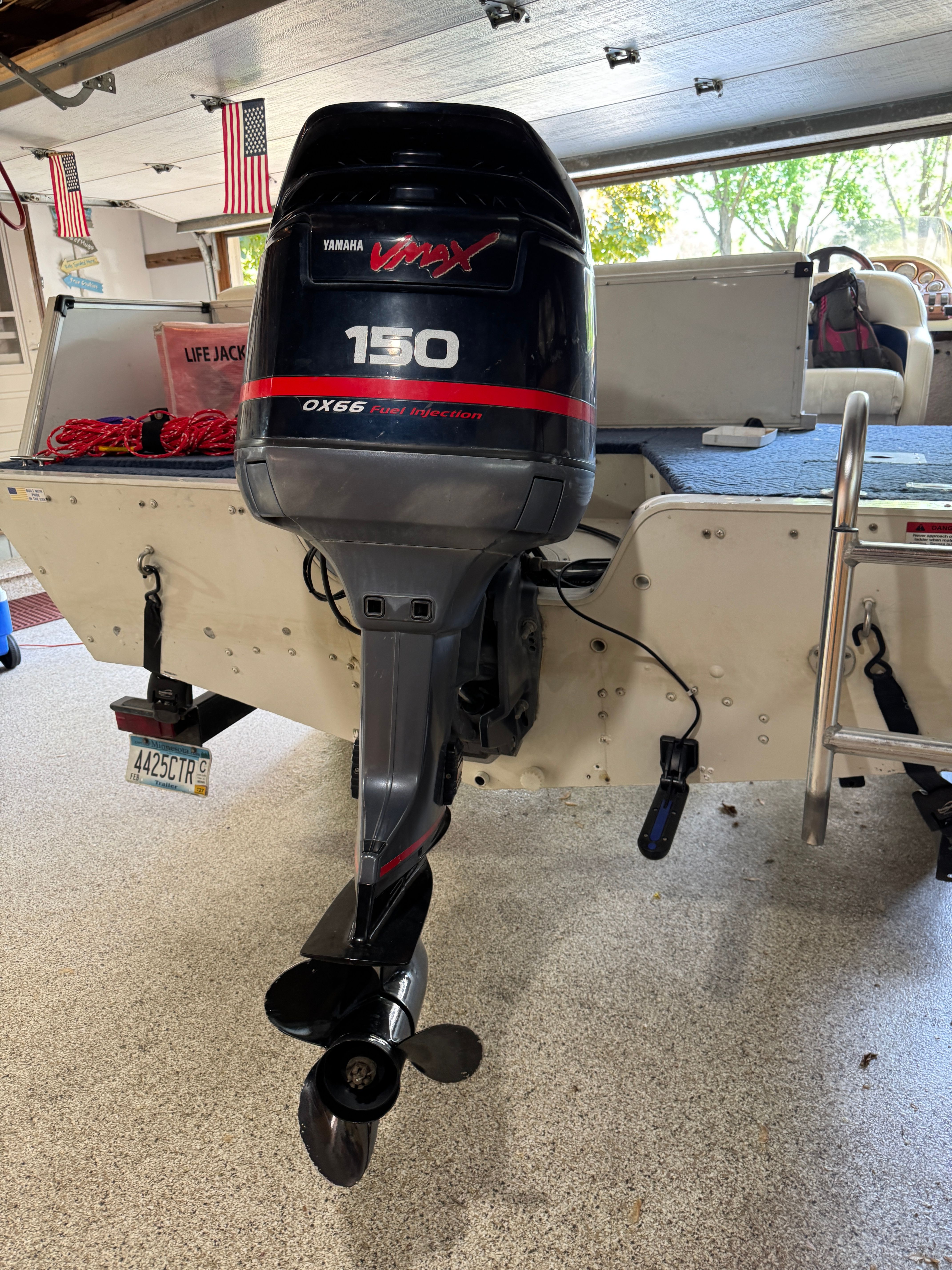 A boat with a Yamaha VMAX 150 outboard motor in a garage.