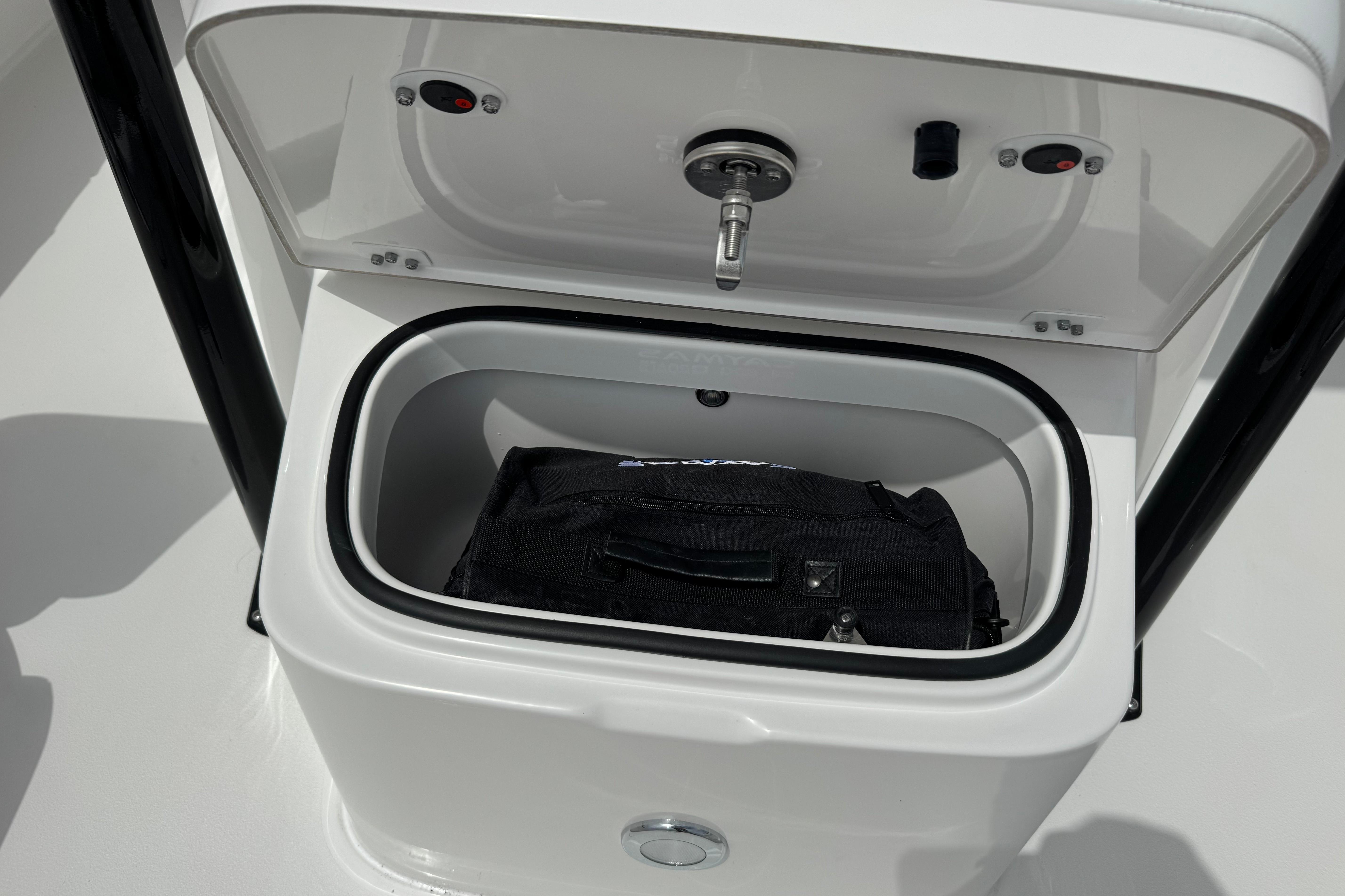 Storage compartment on 2027 Caymas 26 HB boat with a black bag inside.