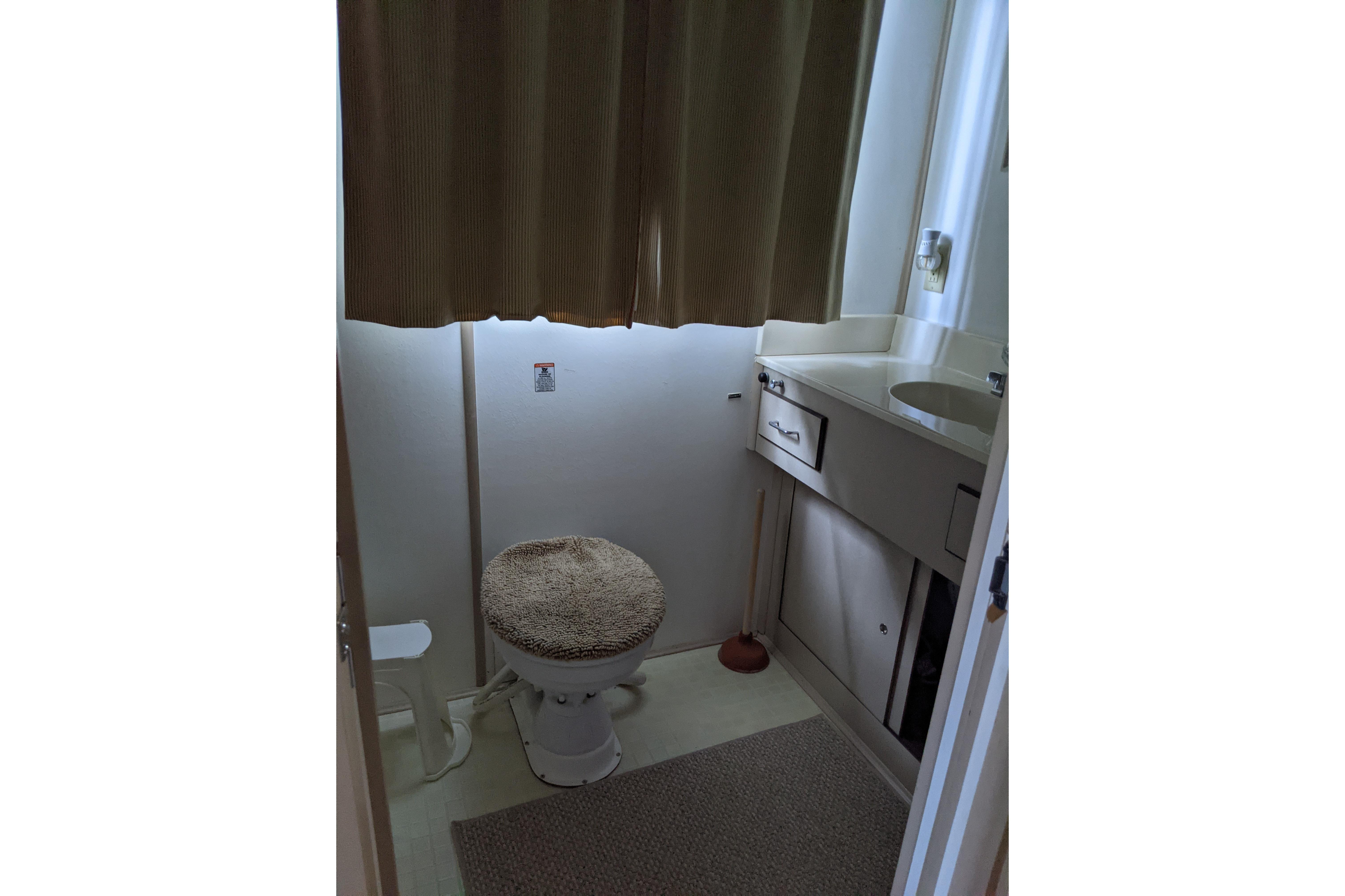Bathroom interior of 2001 Gibson 50 Cabin Yacht with sink and toilet.