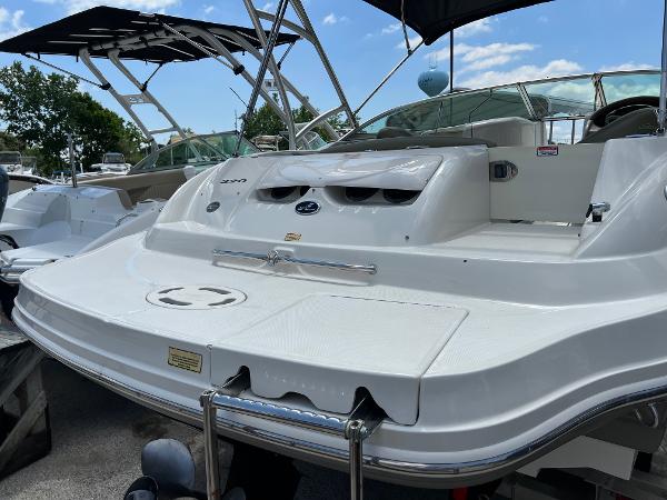2005 Sea Ray 220 Sundeck boat with swim platform and seating, docked under clear sky.