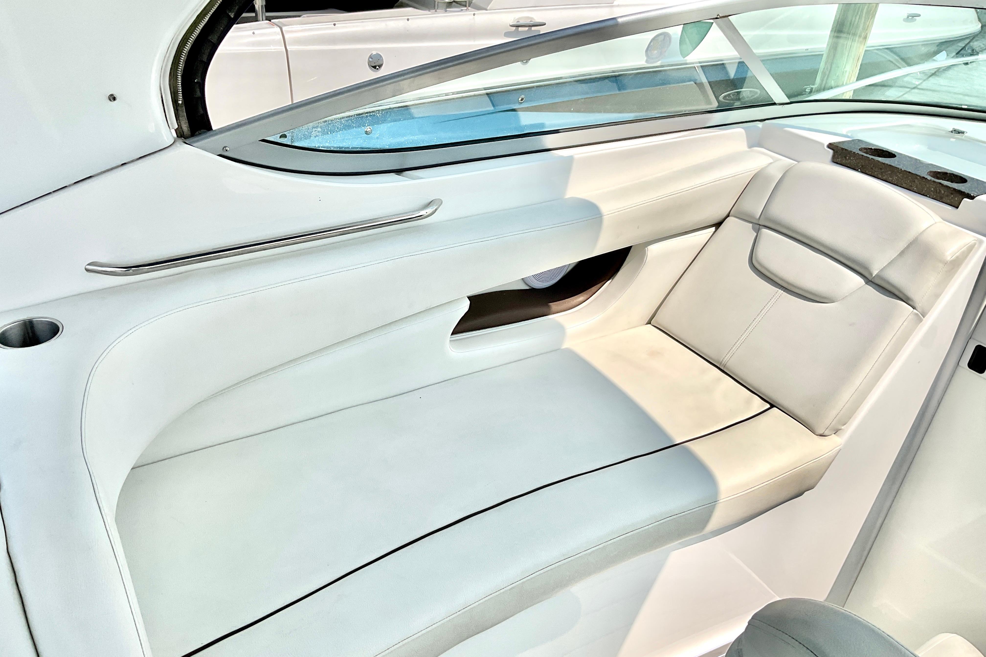 2013 Rinker 290 Express Cruiser interior seating with white upholstery and sleek design.