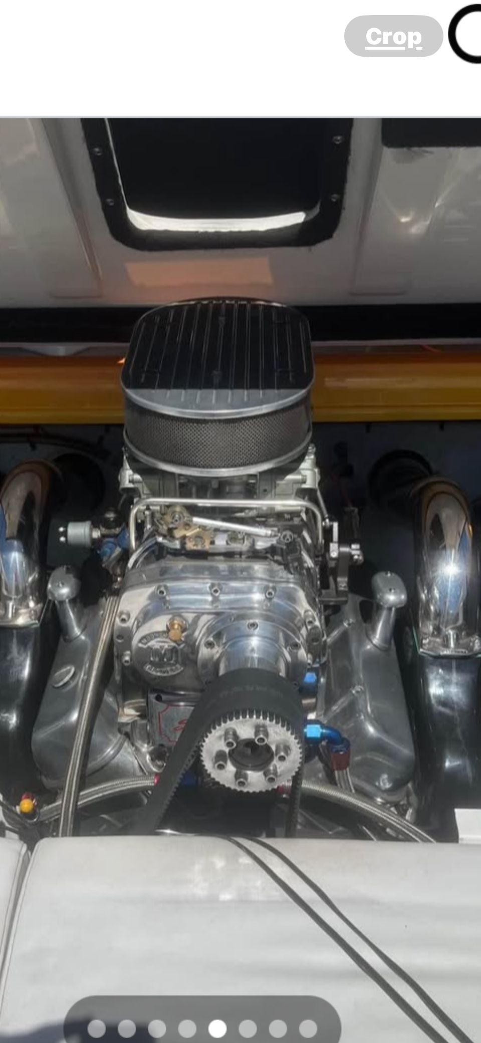 A powerful engine is visible inside a boat, surrounded by shiny metal components.