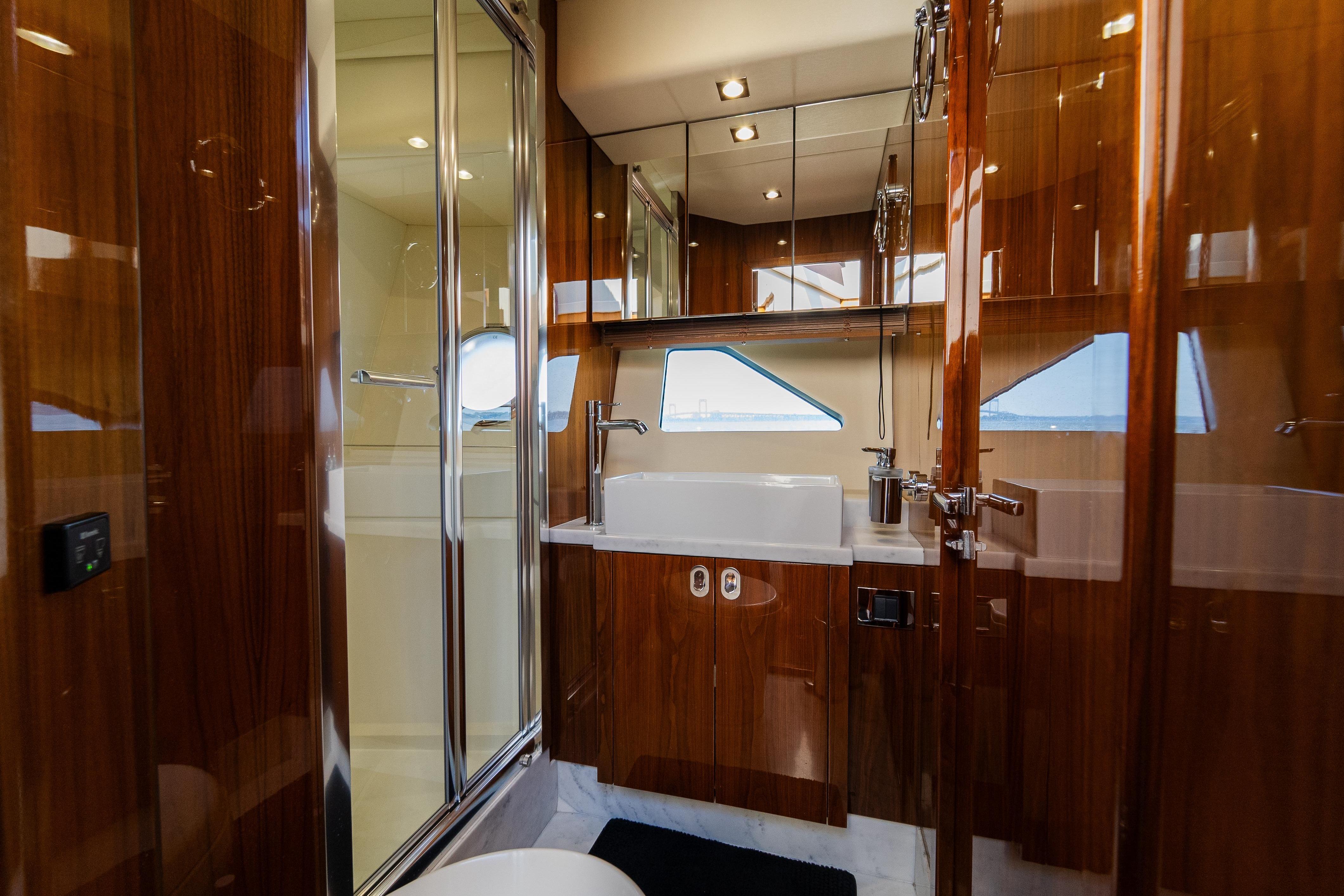 Luxurious bathroom interior of 2016 Sunseeker Manhattan 65 yacht with wood finishes.