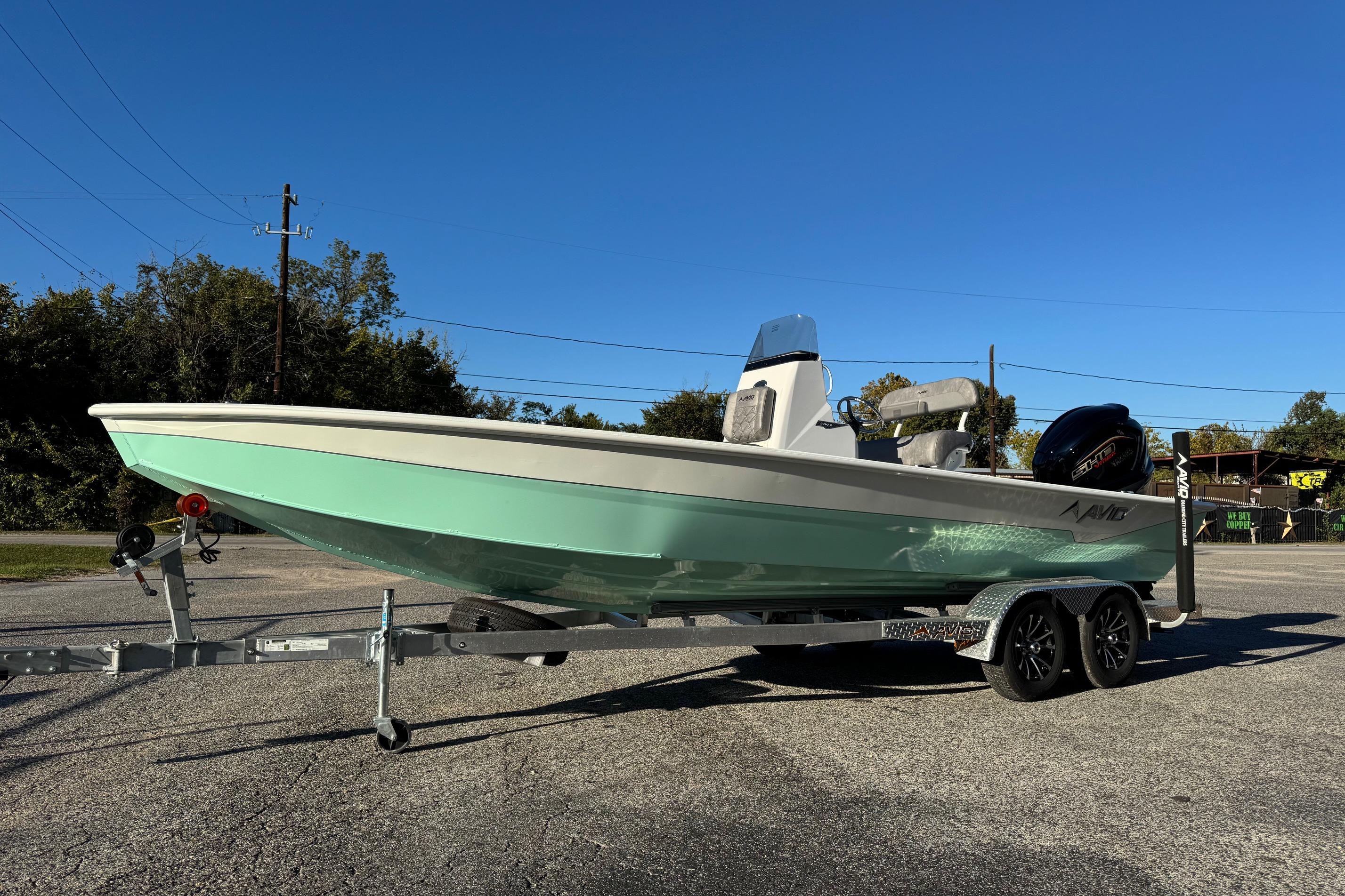 2025 Avid 23 Mag boat on trailer under clear blue sky.