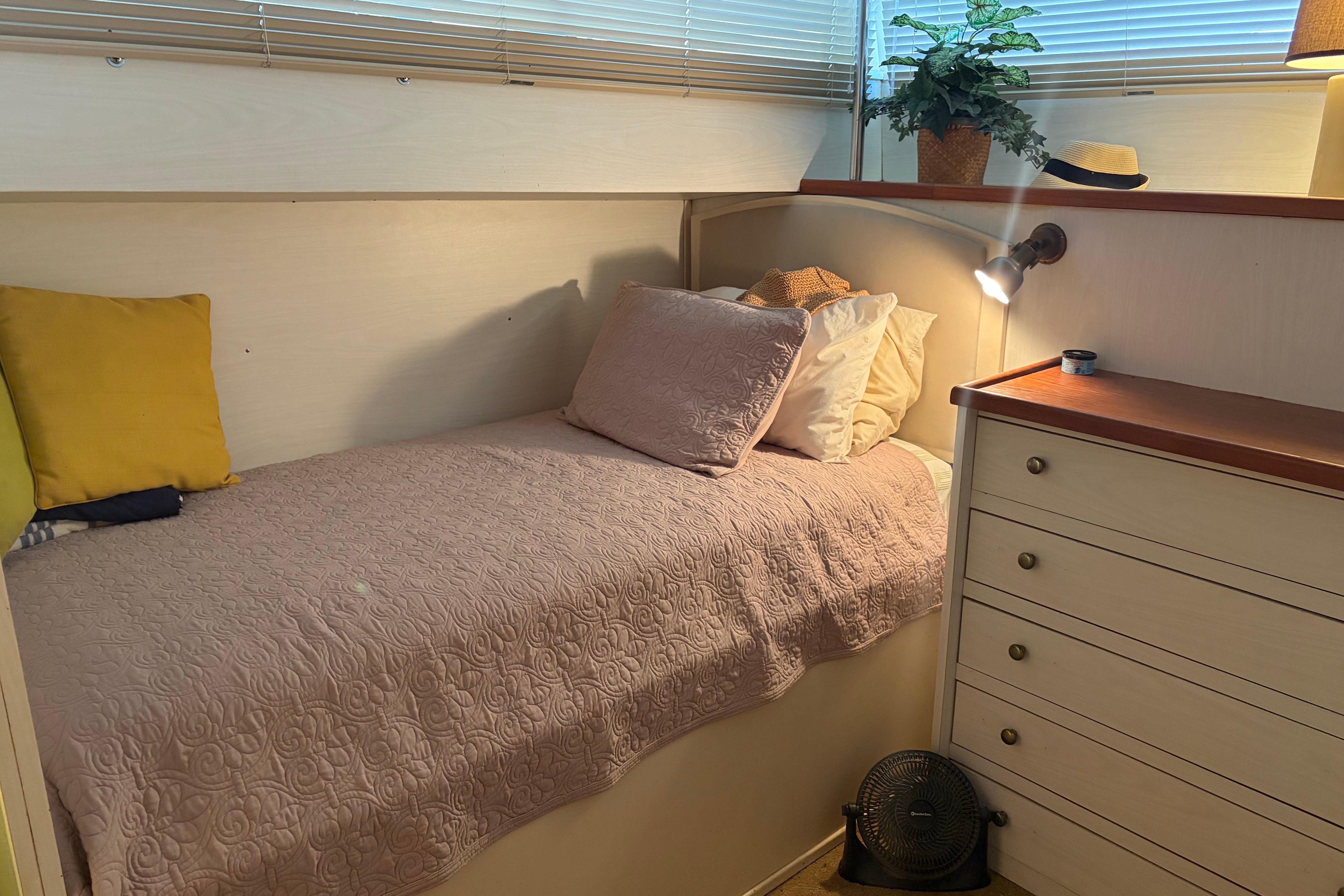 Cozy cabin interior of 1971 Chris-Craft 42 Commander with bed, pillows, and dresser.