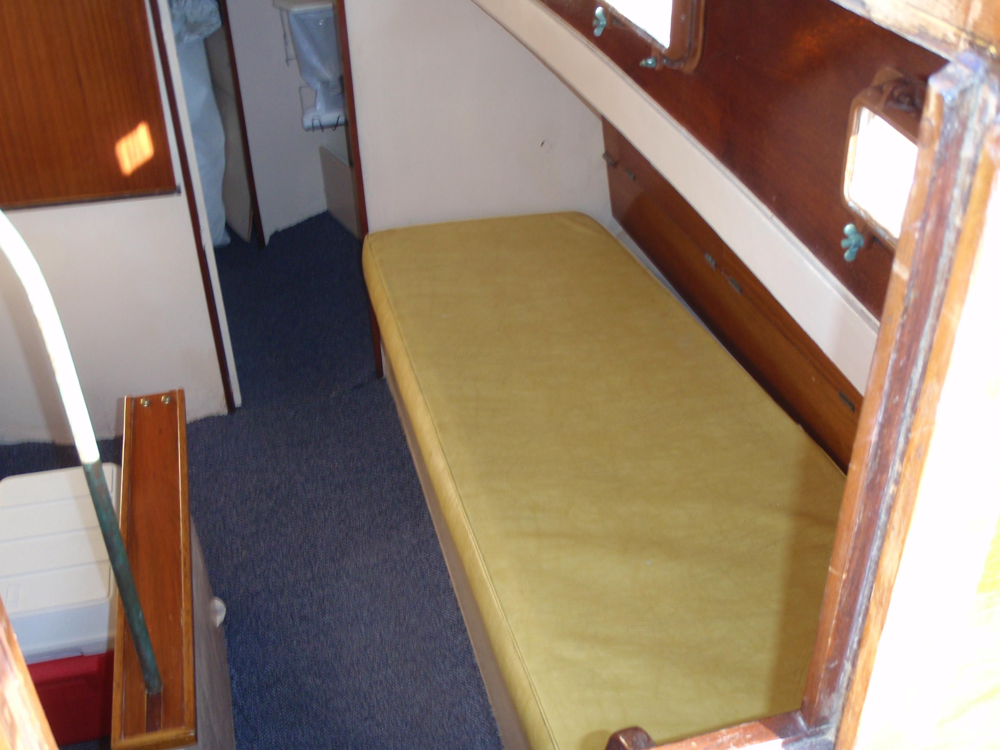 Interior of a 1963 Glander Tavana boat with yellow mattress.