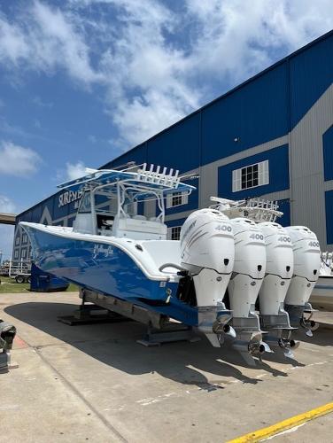 2022 Yellowfin 39 Offshore boat with four powerful engines, parked near a blue building.