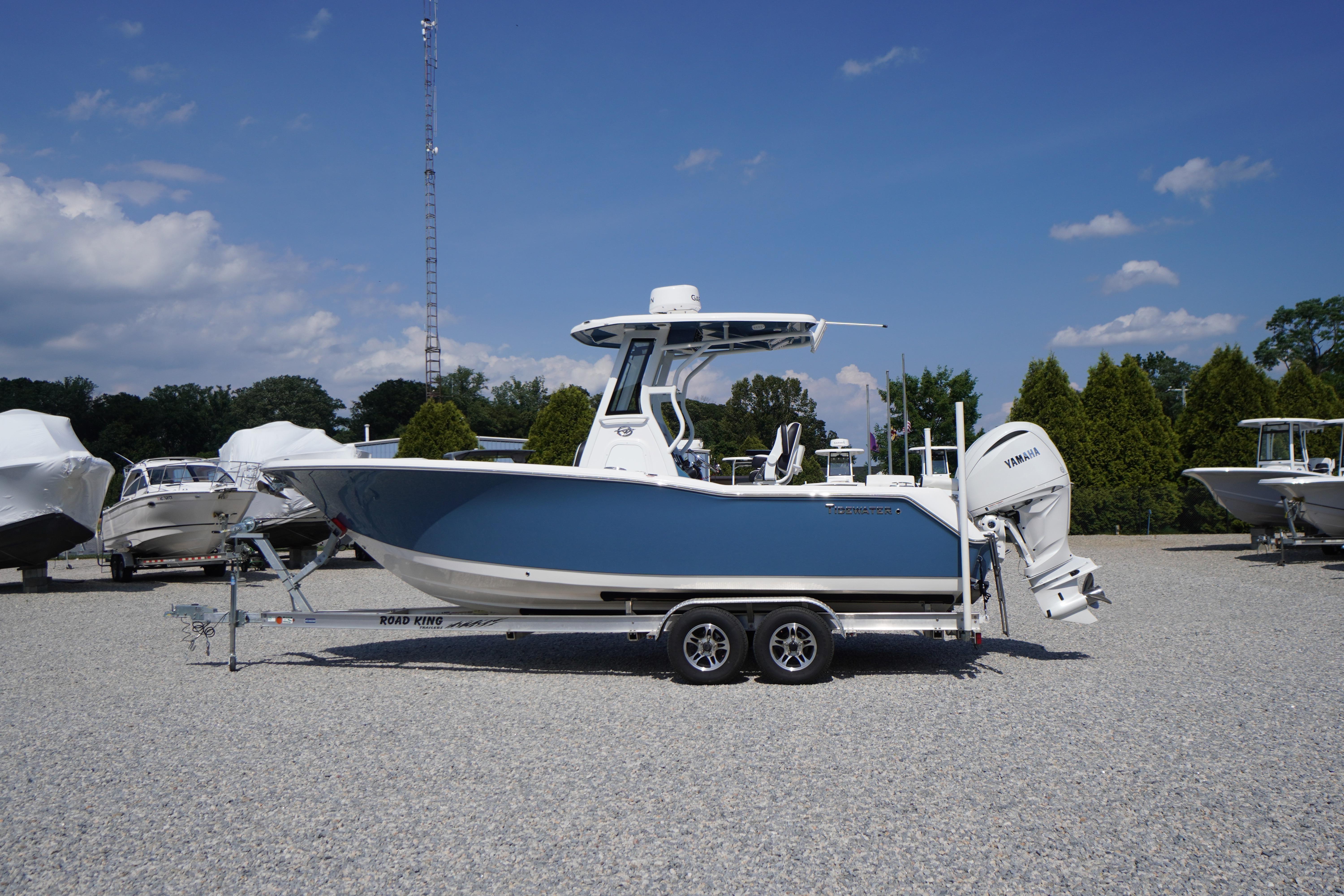 2025 Tidewater 232 SS boat on trailer, blue hull, parked outdoors under clear sky.