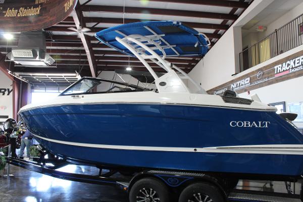 2025 Cobalt R6 boat in showroom, blue and white design, on trailer.