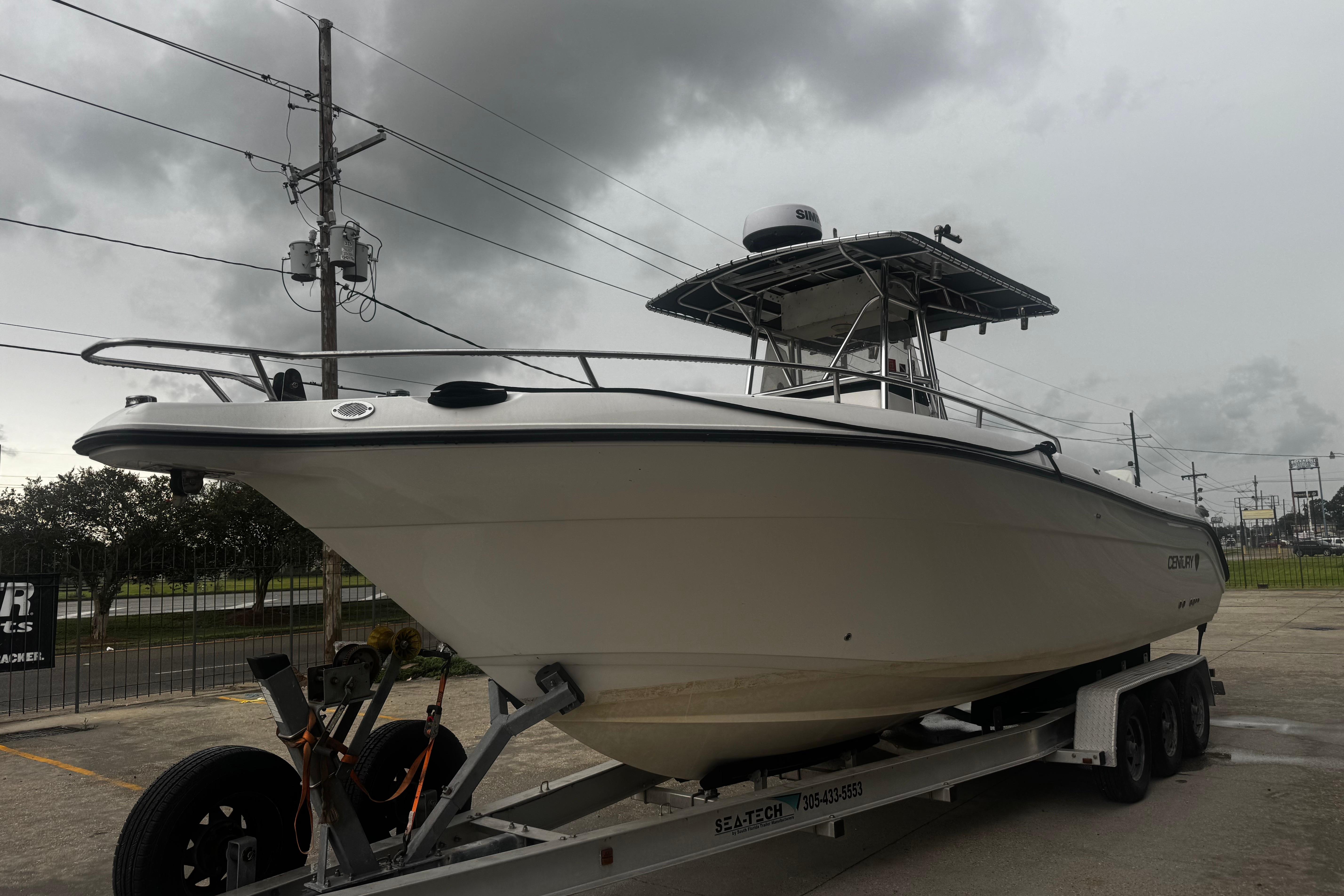 2004 Century 2900 Center Console boat on trailer under cloudy sky.