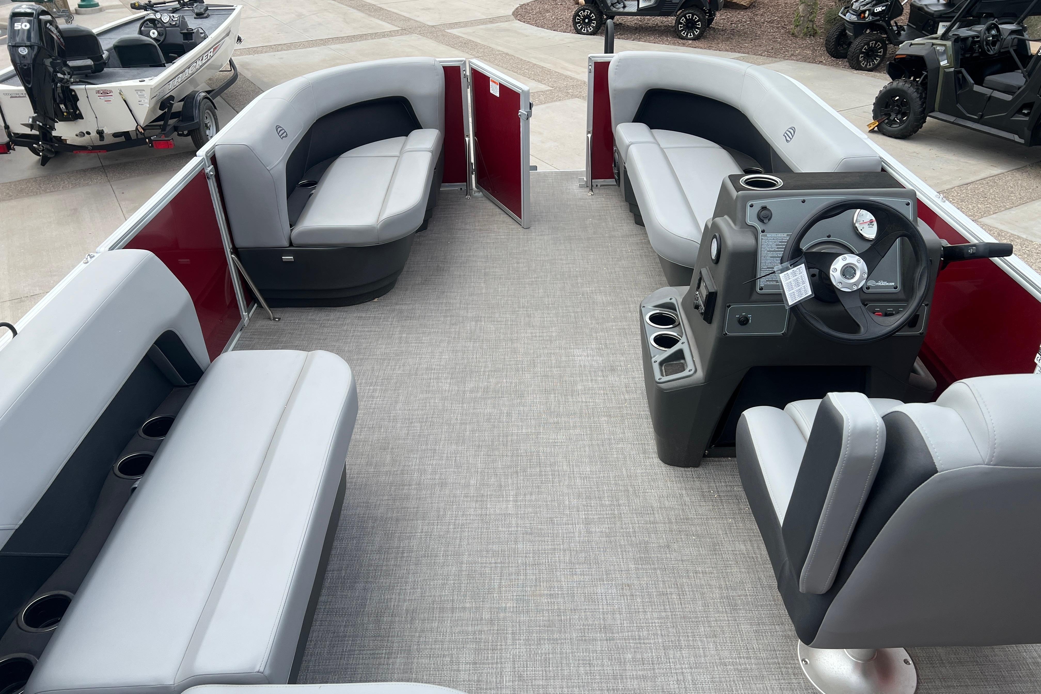 2026 Sun Tracker Party Barge 16 DLX interior with gray seating and steering console.