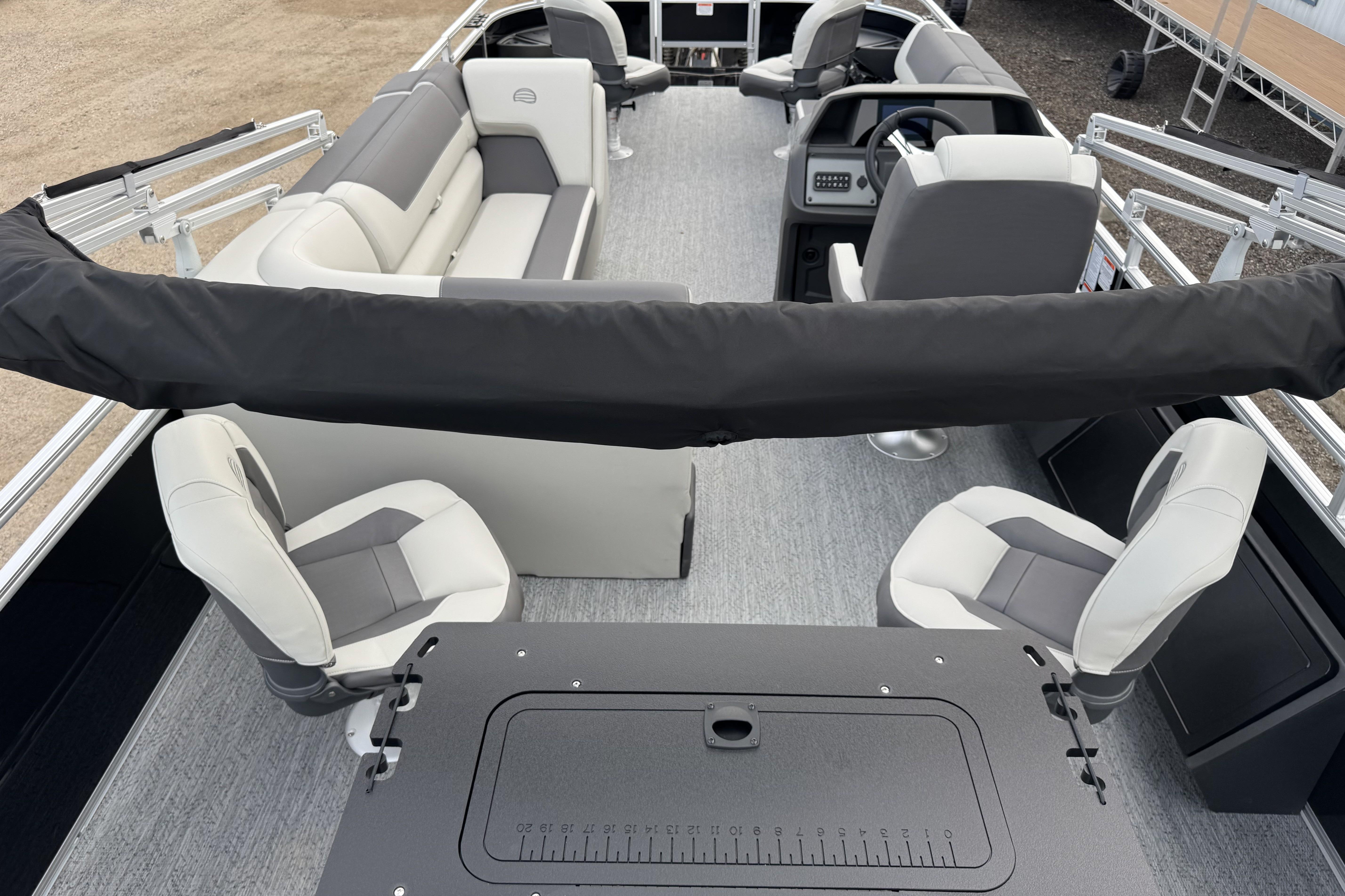 2026 Sun Tracker Fishin' Barge 22 DLX interior with seating and steering console.