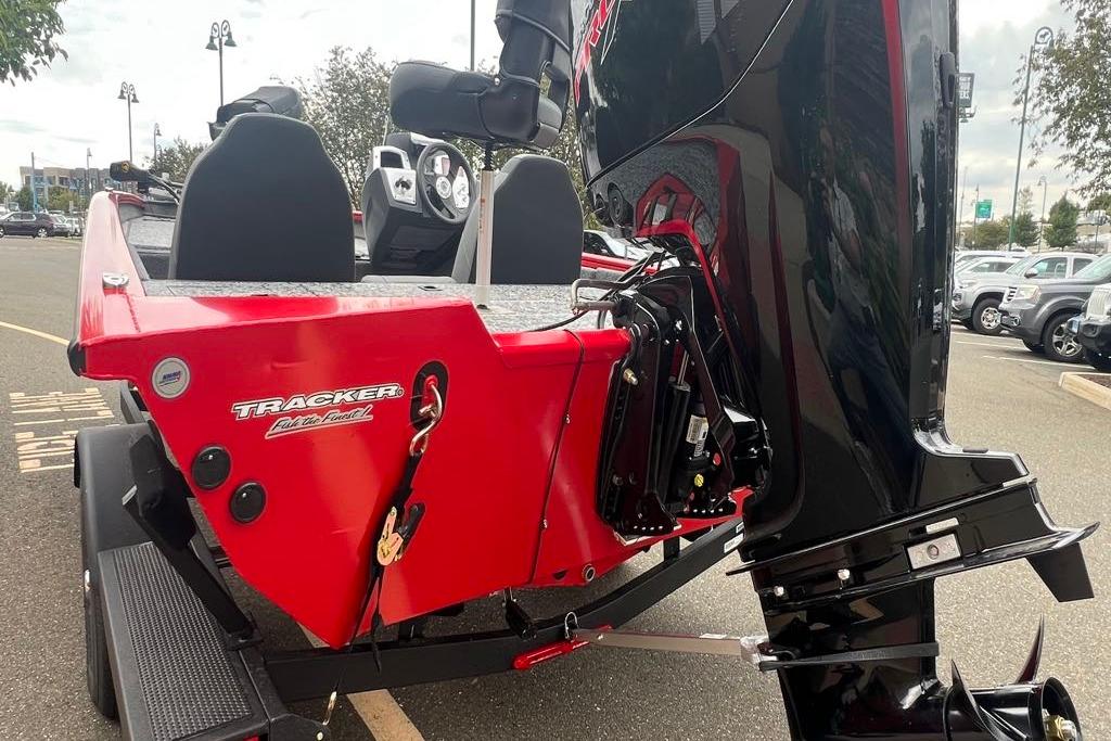 2026 Tracker Pro Team 190 boat, red exterior, powerful outboard motor, parked outdoors.