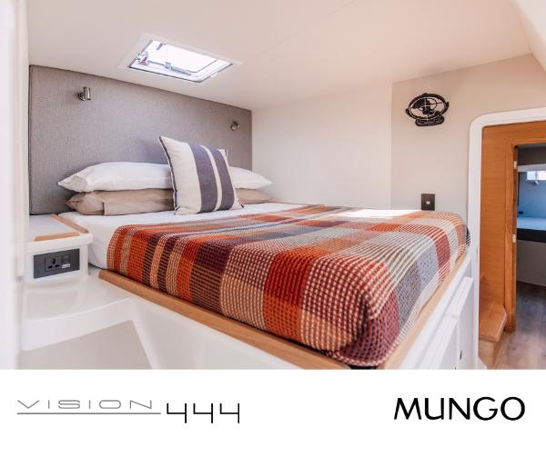 Cozy bedroom interior of Vision 444 yacht, featuring a plaid blanket and modern design, 2026 model.