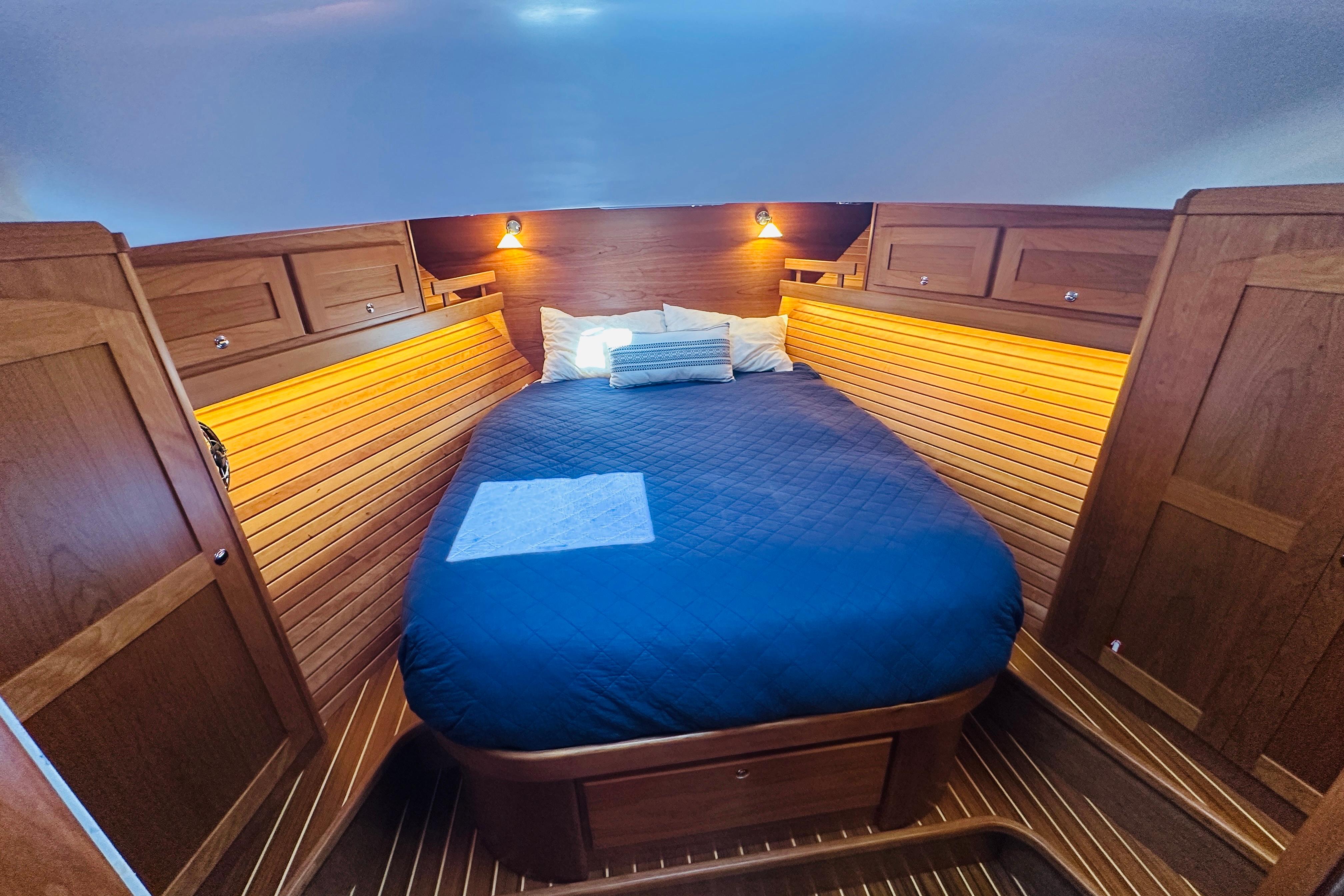 Luxurious cabin interior of 2025 Sabre 48 Salon Express with cozy bed and wooden finish.