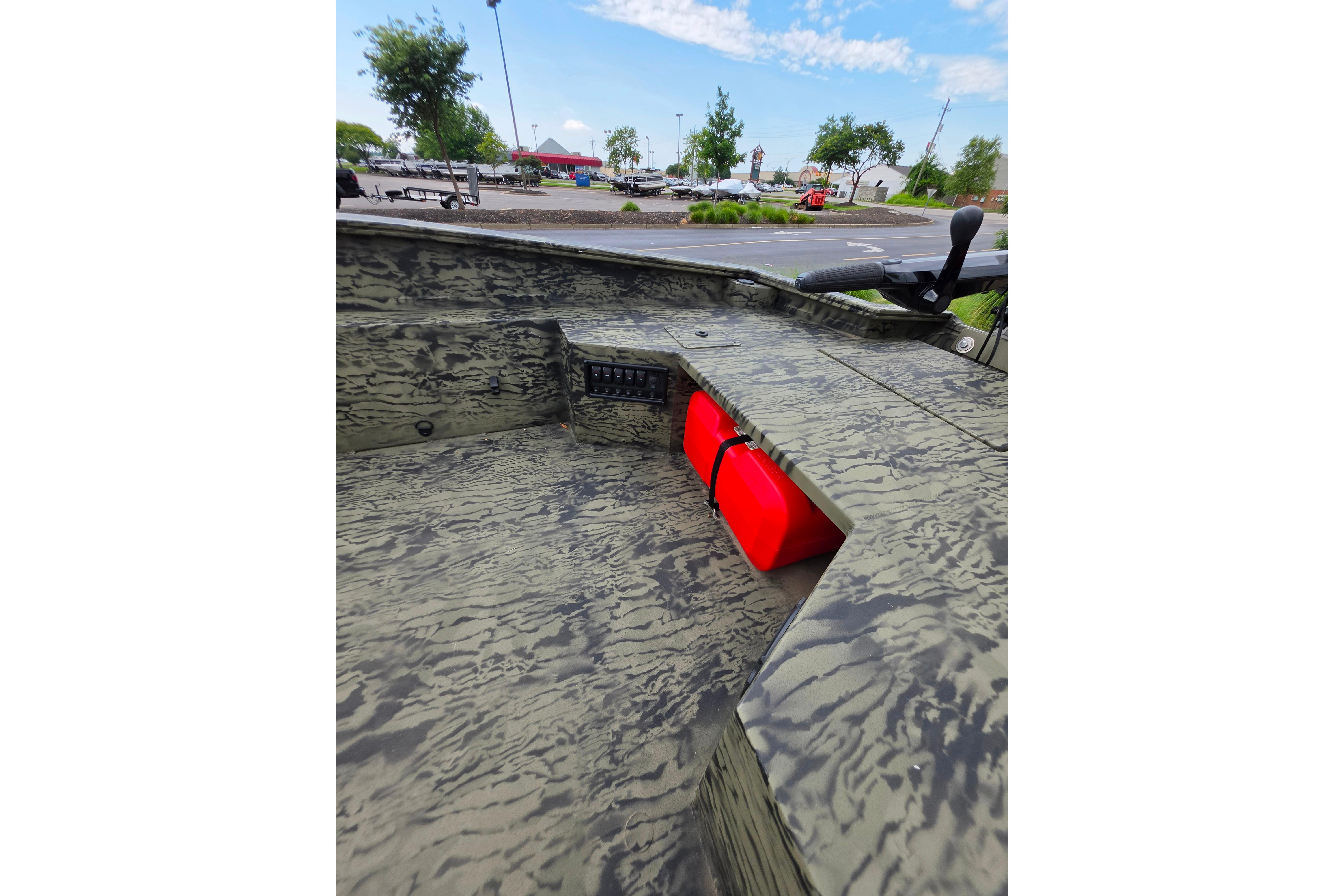 2026 Tracker Grizzly 1650 T Prairie Wings Edition boat interior with camouflage design and red storage compartment.