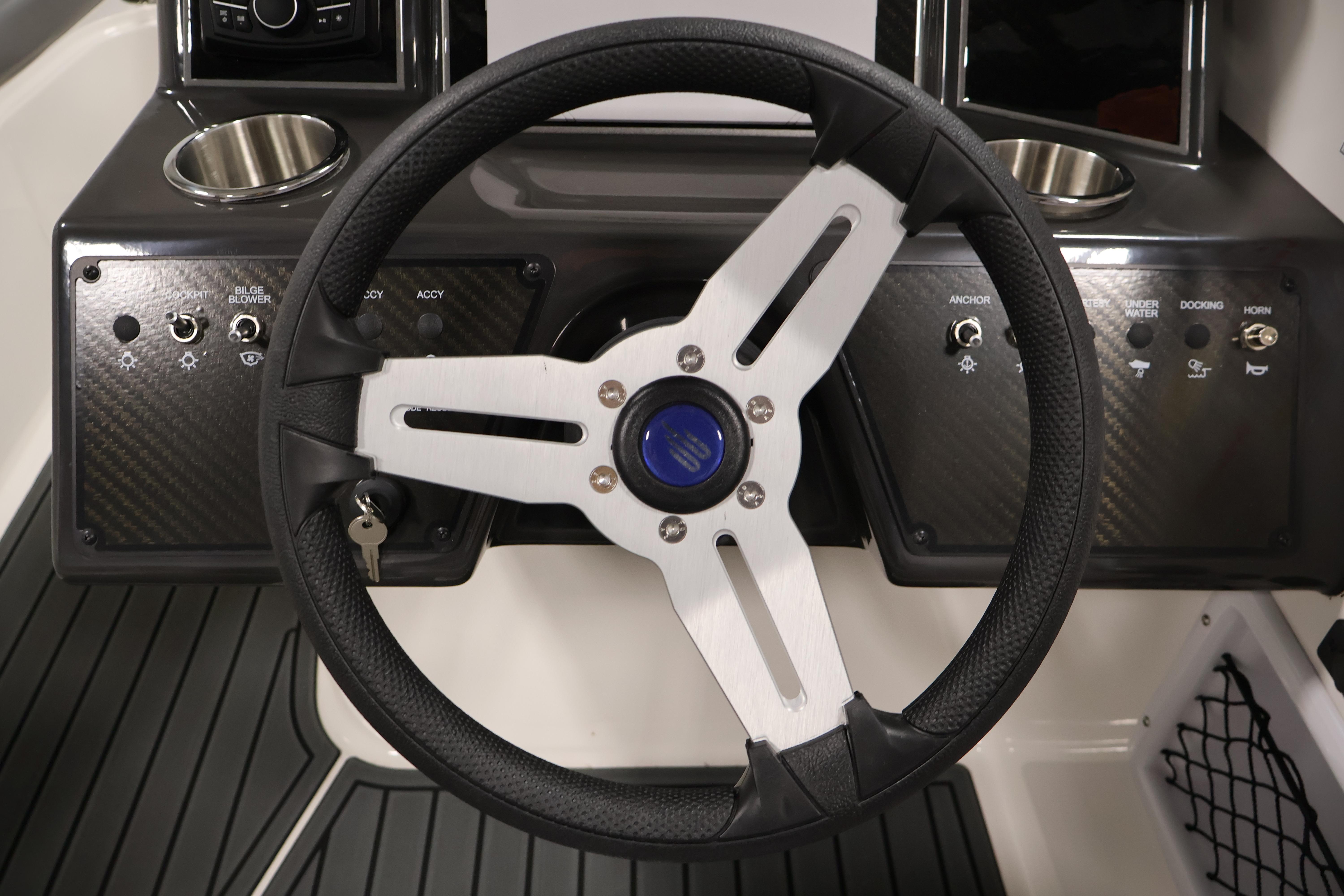 Steering wheel of 2026 Bayliner VR6 Bowrider I/O with control panel and cup holders.