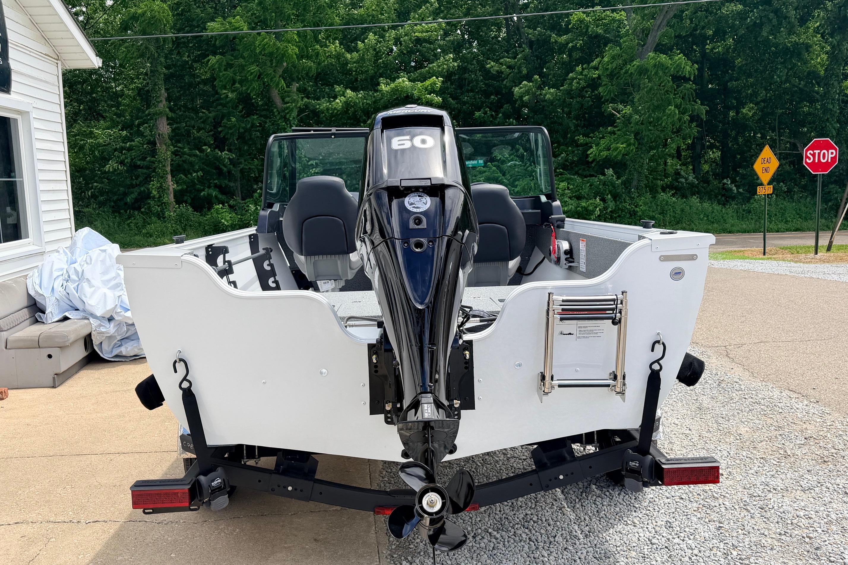 2026 Crestliner 1650 Kodiak WT boat with 60 HP motor, parked outdoors.