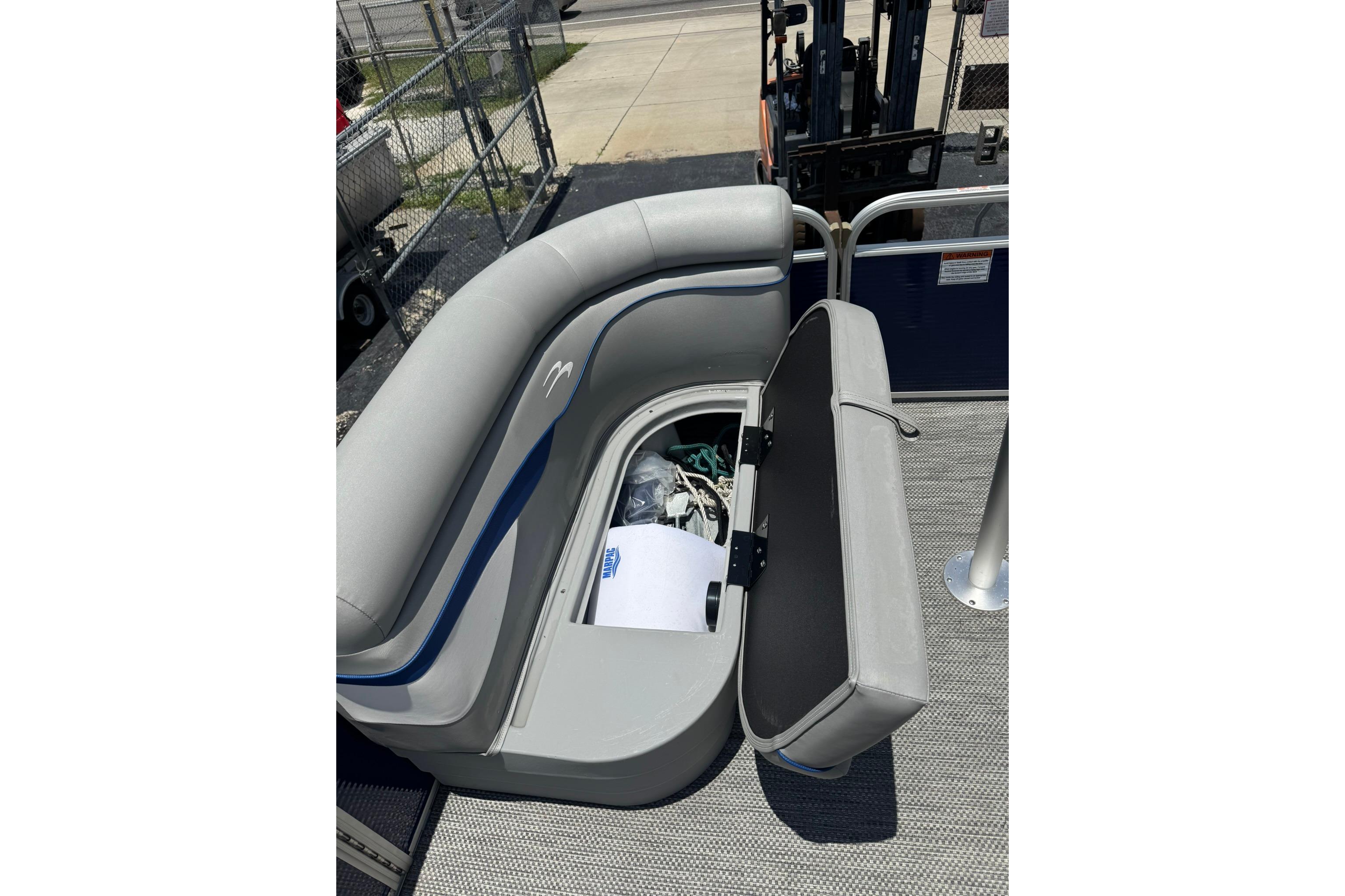 2024 Bennington SV 168 SLV boat with open storage compartment under gray seating.