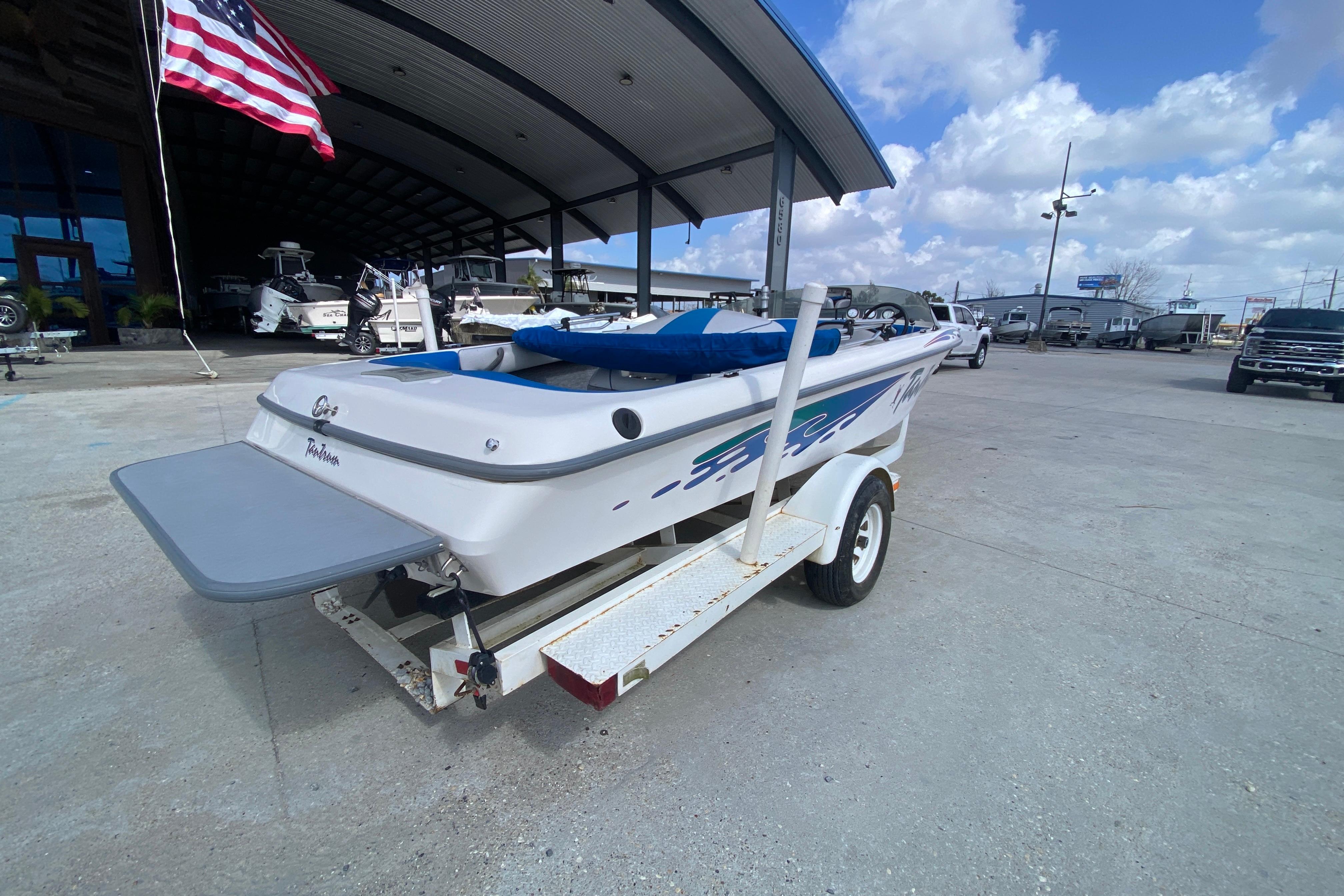1997 Malibu Tantrum boat on trailer, parked outdoors under a clear sky.