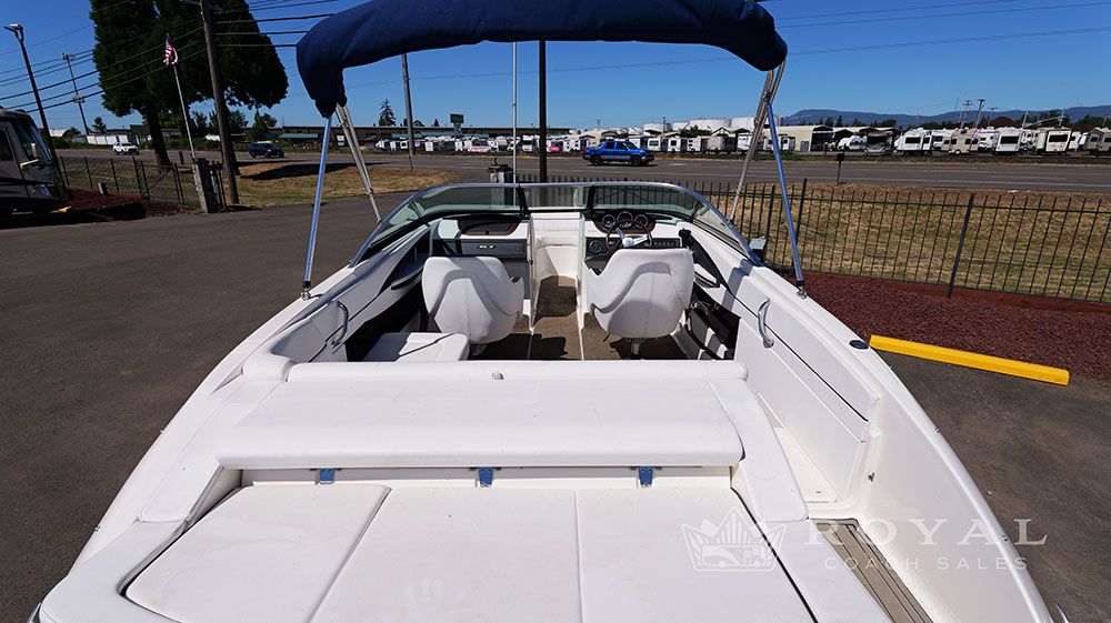 2014 Sea Ray SLX 230 with open cockpit and blue Bimini top.