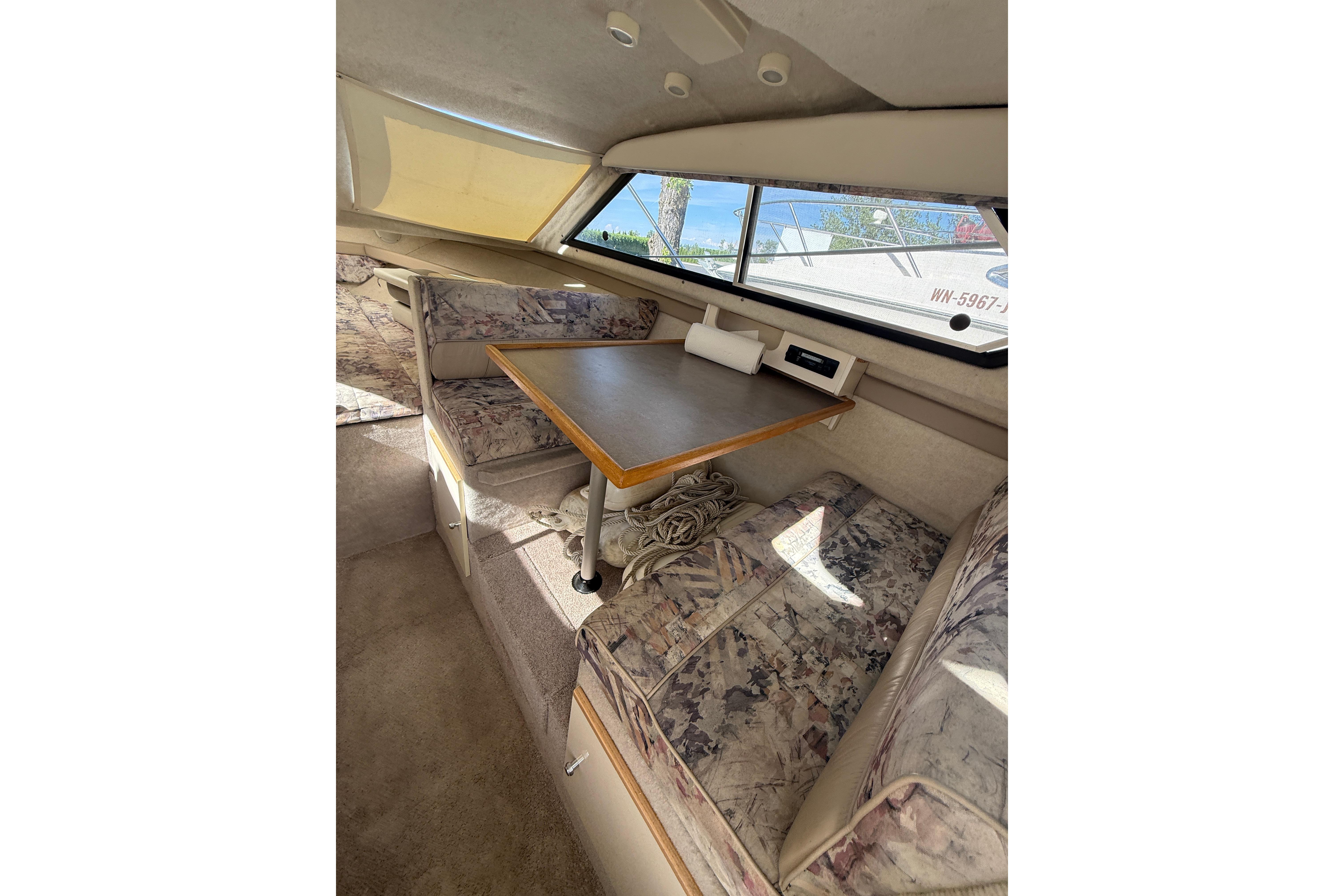 Interior of 1997 Bayliner 2452 Ciera Express with dining area and patterned seating.