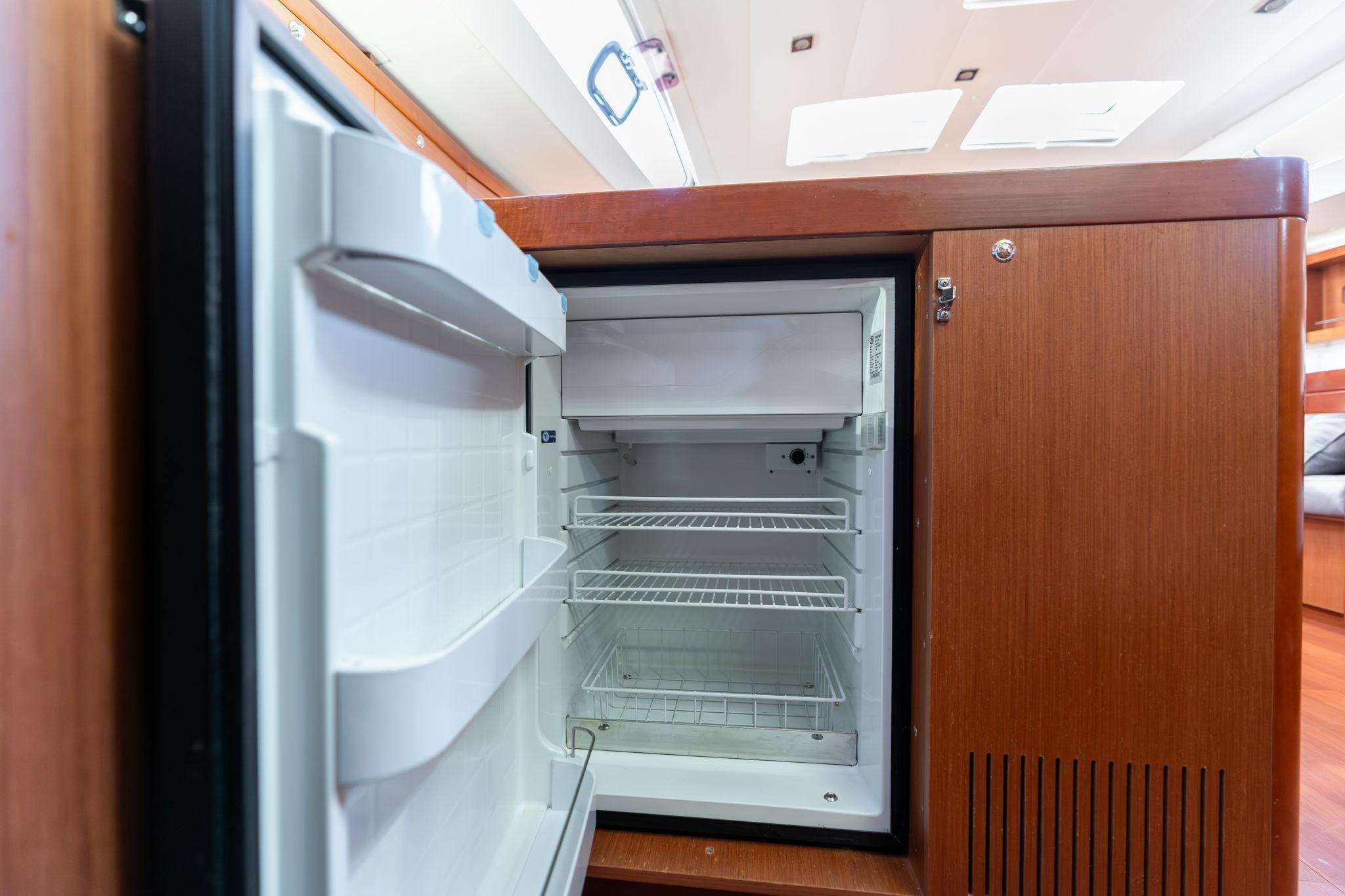 Open refrigerator inside 2013 Beneteau Oceanis 50 yacht, showcasing interior shelving.