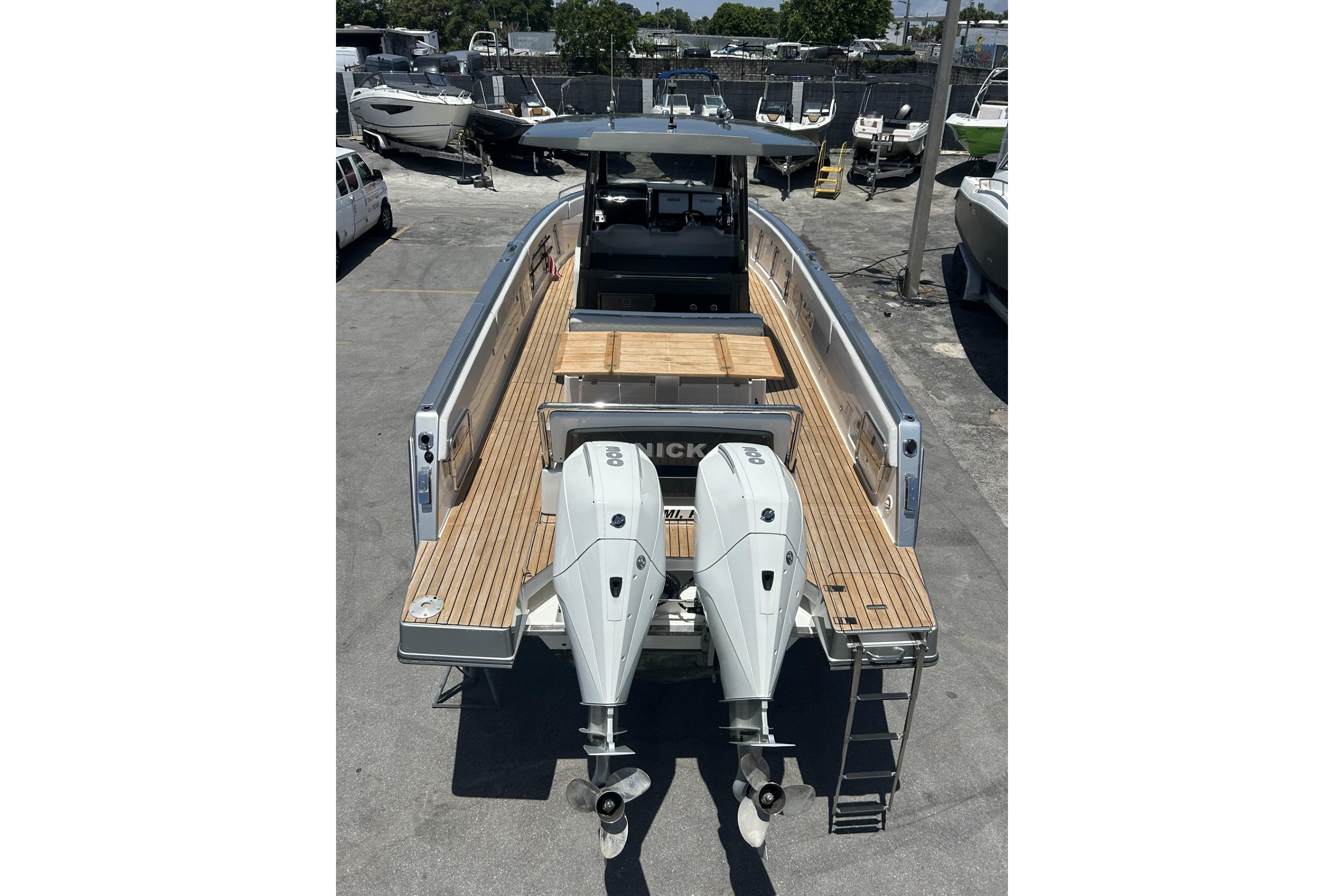 2023 Schaefer V33 boat with dual outboard engines, docked in a marina.