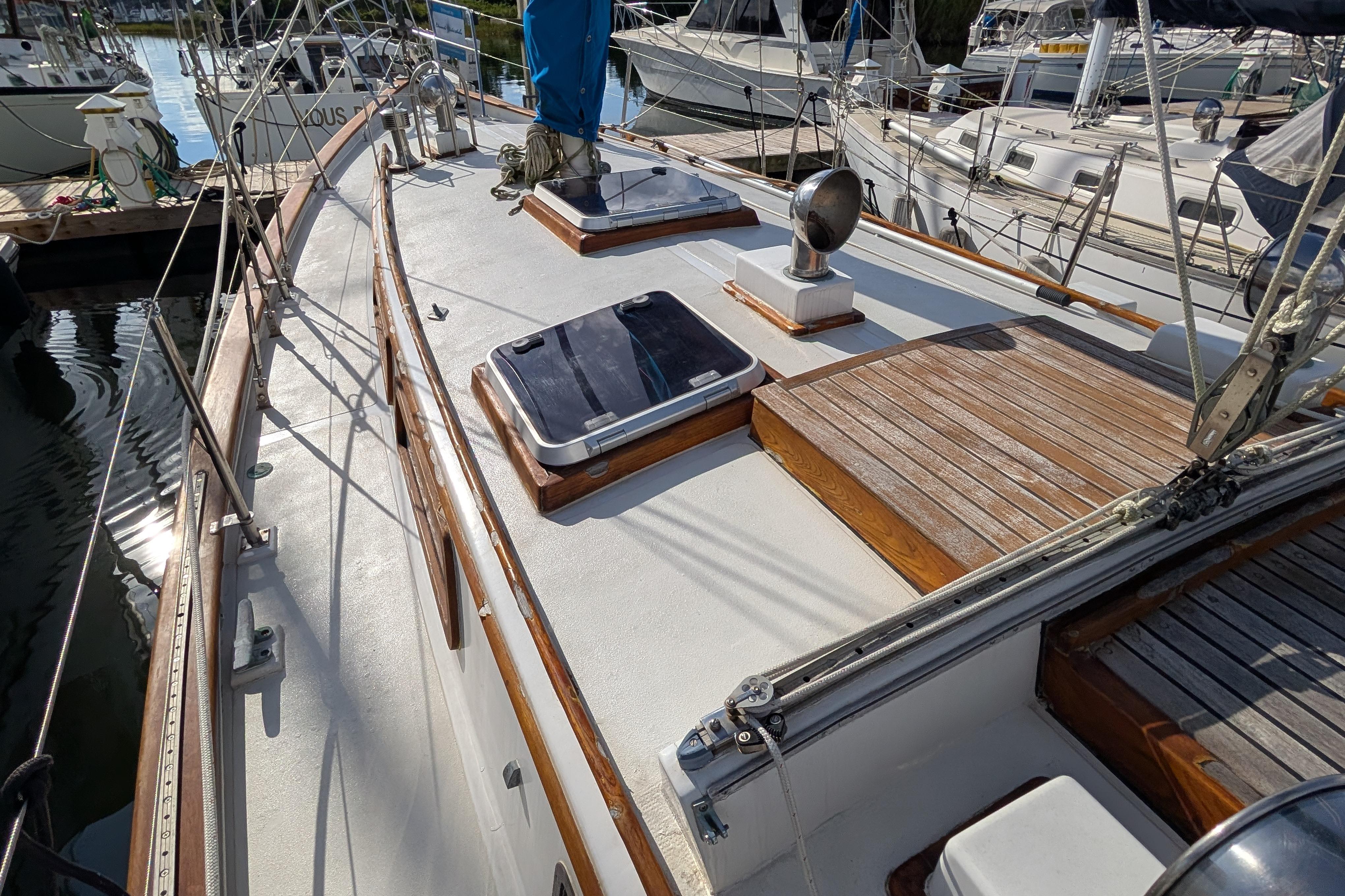 1983 Robert Perry 41 sailboat deck with wooden accents and marina background.