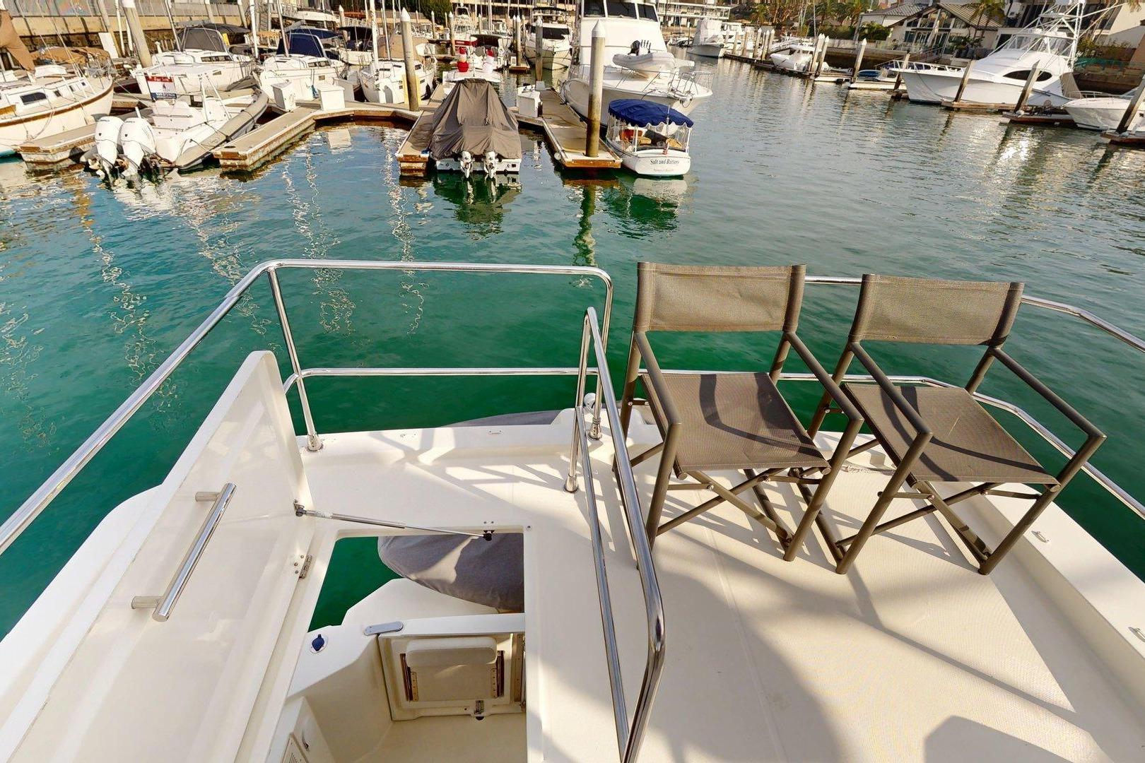 Flybridge view of 2021 Beneteau Swift Trawler 35, overlooking marina with docked boats.