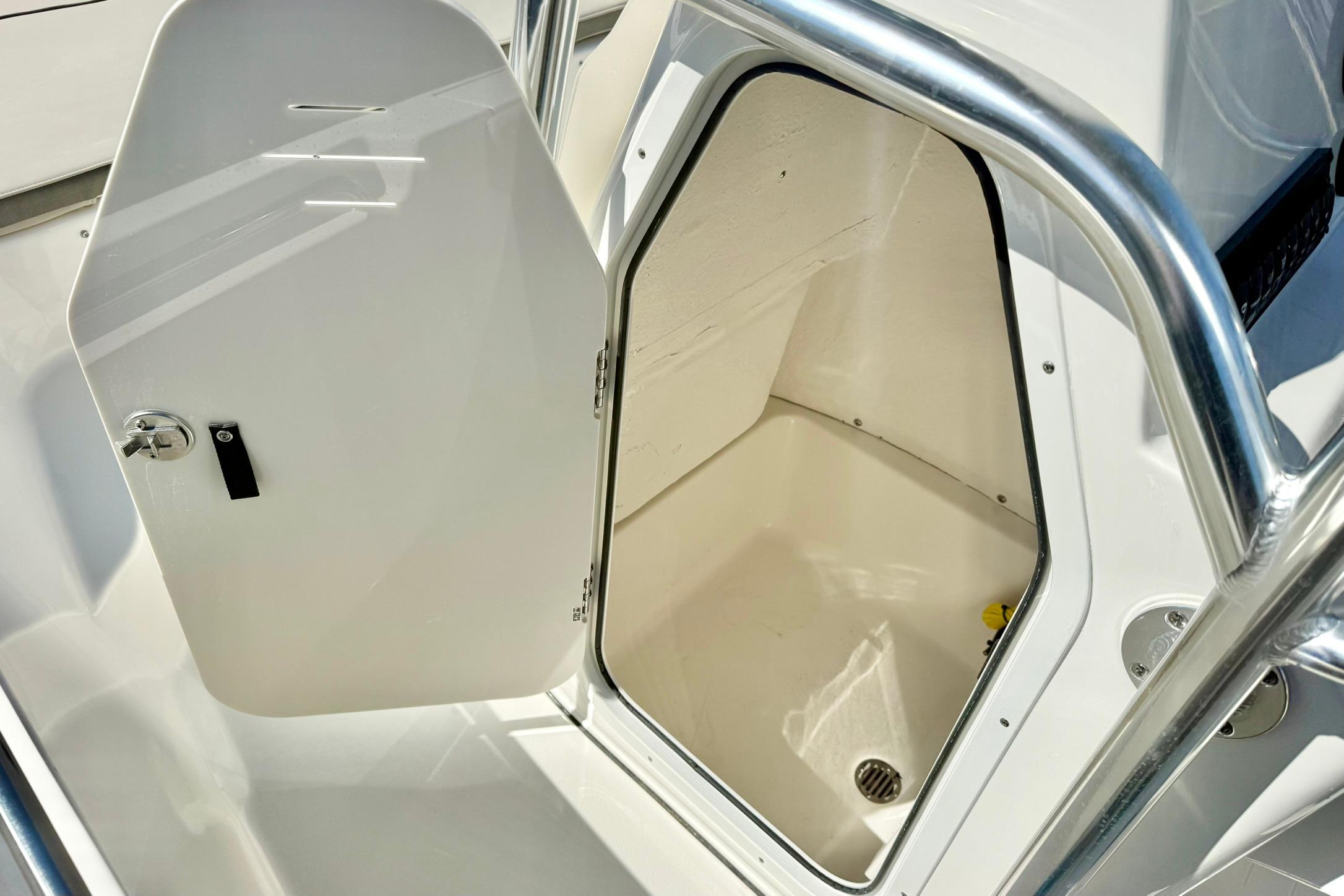 2026 Key West 189 FS boat storage compartment with open door and stainless steel railing.