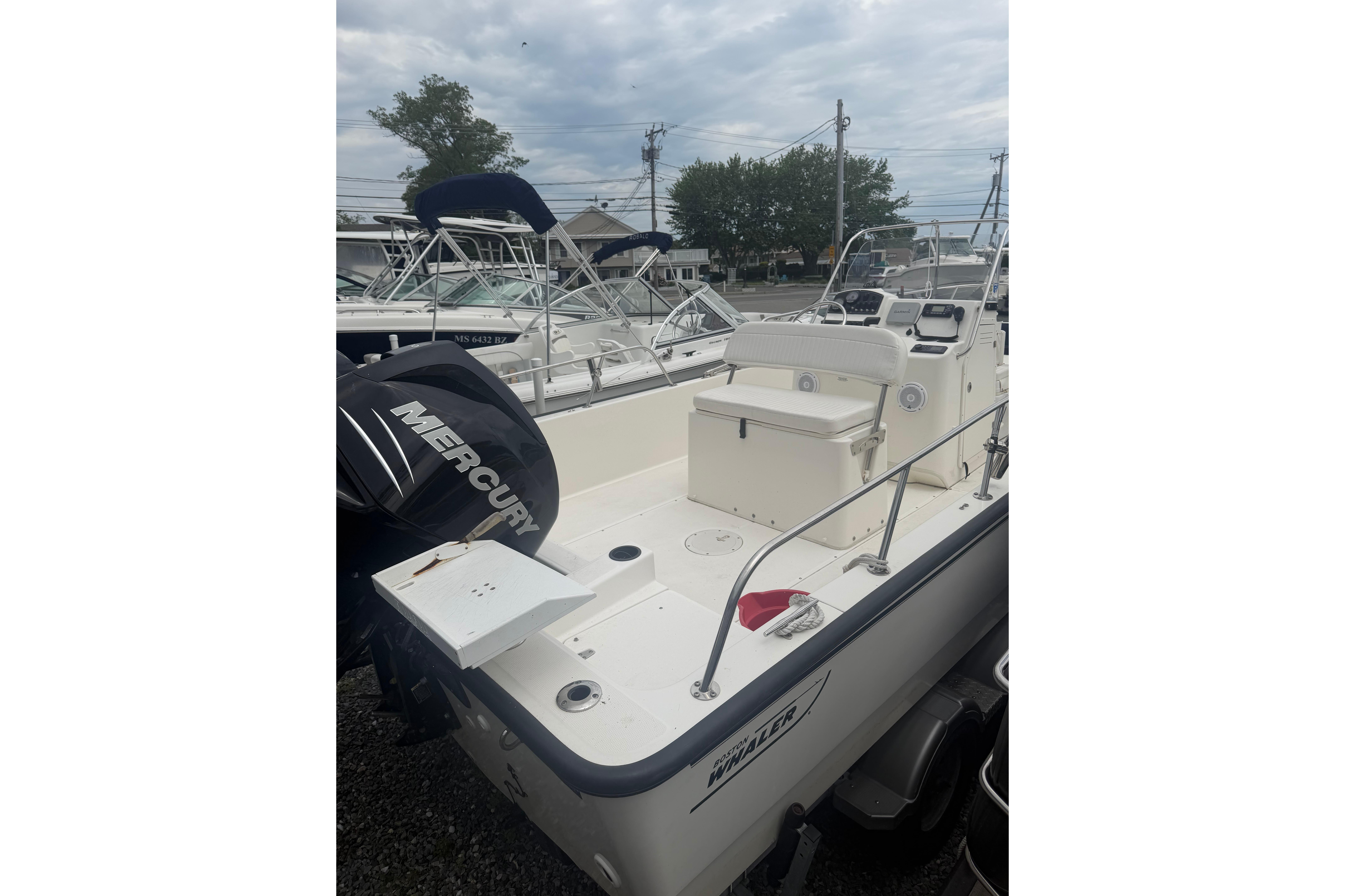 2015 Boston Whaler 210 Montauk boat with Mercury engine, docked outdoors.