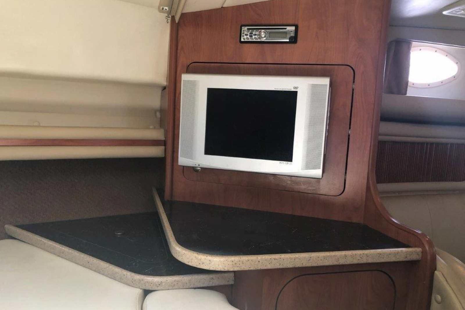 2006 Rinker 342 Express Cruiser interior with TV and wooden cabinetry.