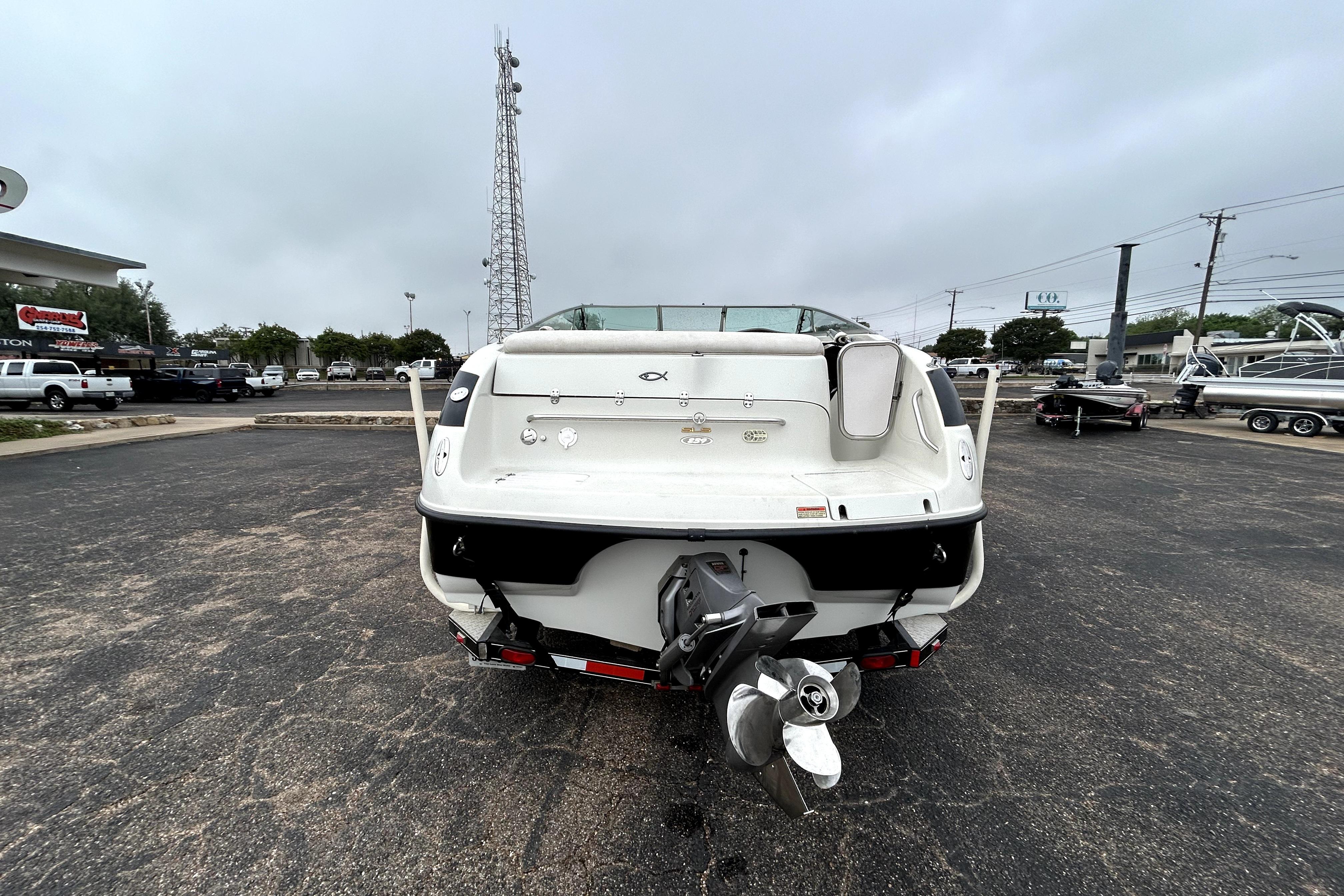 Rear view of a 2001 Crownline 239 DB boat in a parking lot.