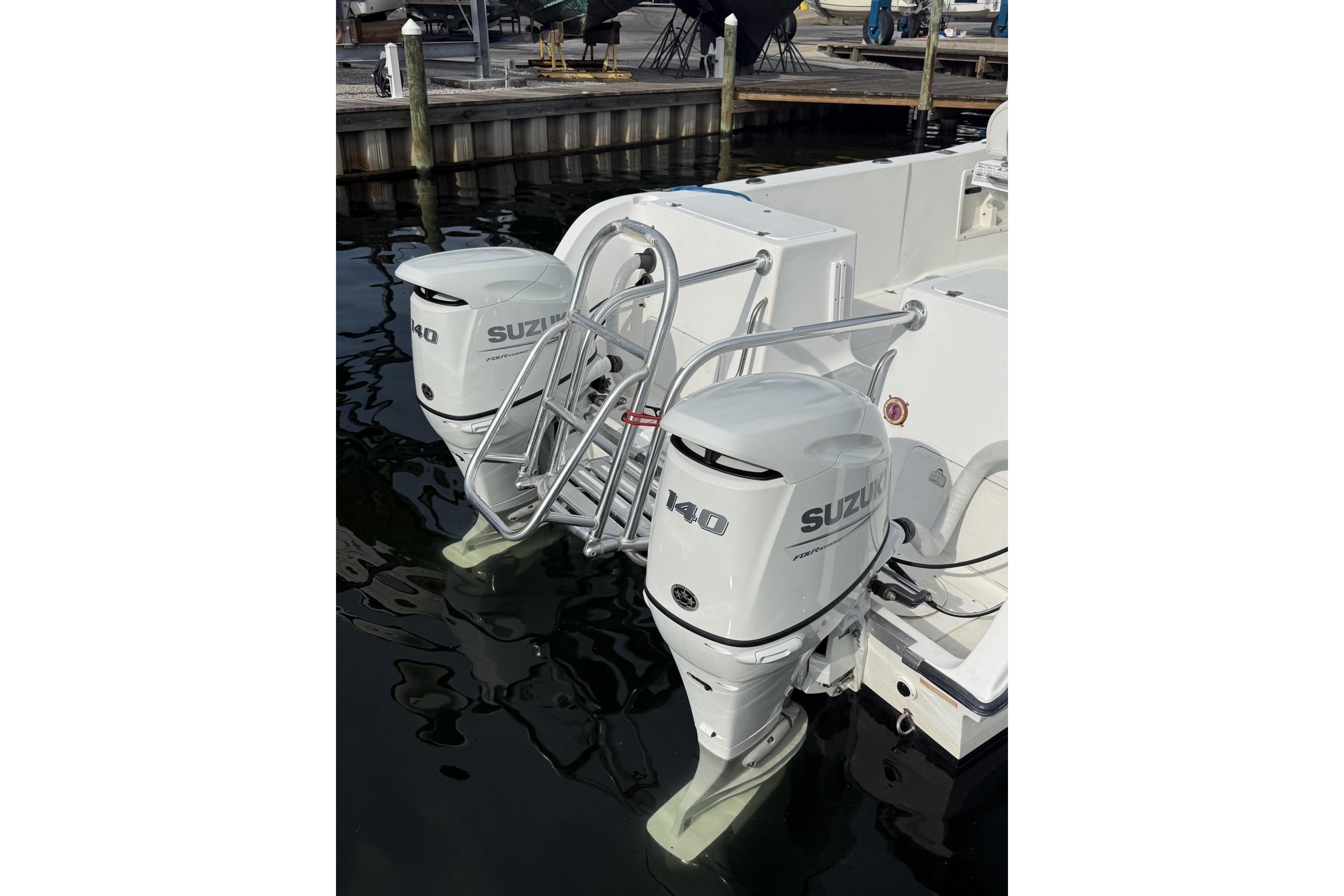 2002 Pro Sports 2200 CC ProKat with twin Suzuki 140 outboard motors at dock.