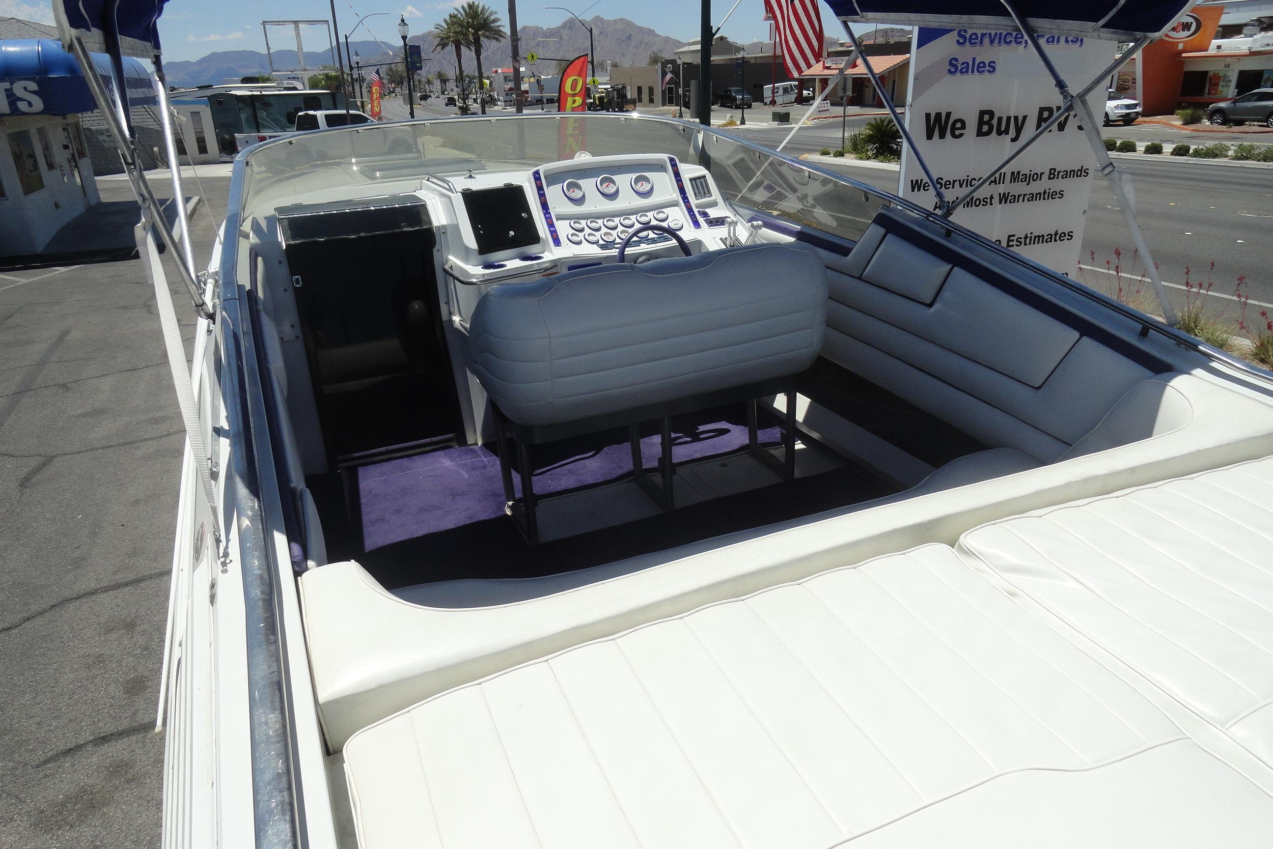 1988 Wellcraft 34 Scarab boat interior with white seating and control panel, parked outdoors.