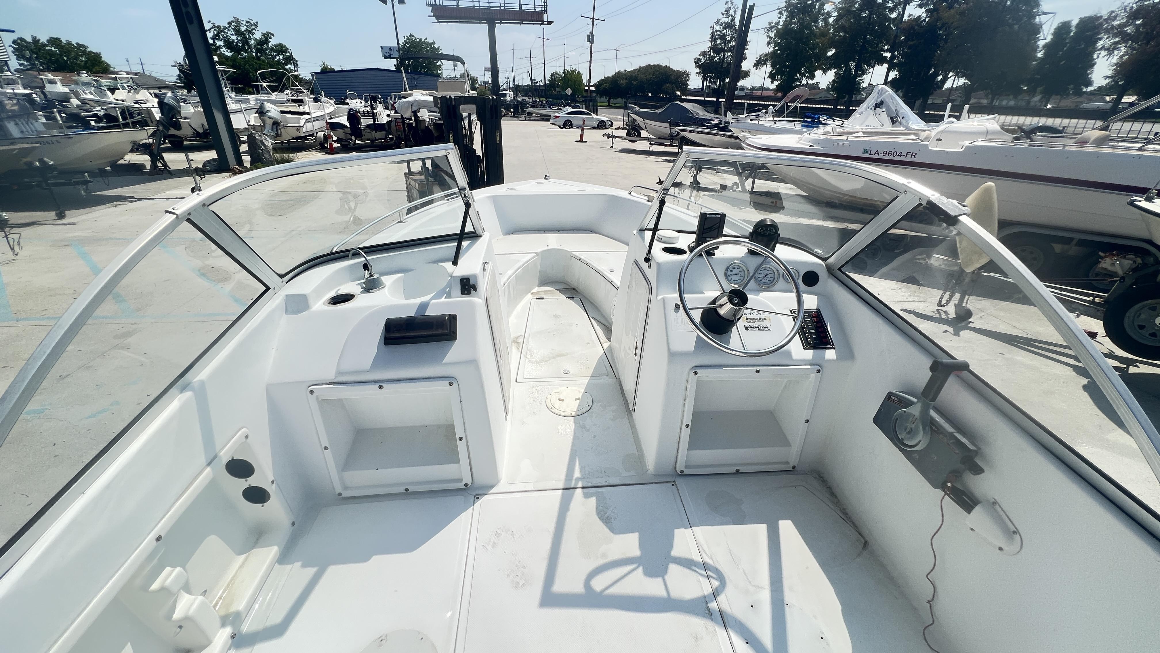 1998 Pro Sports Walk Through boat interior with steering wheel and dashboard, docked outdoors.