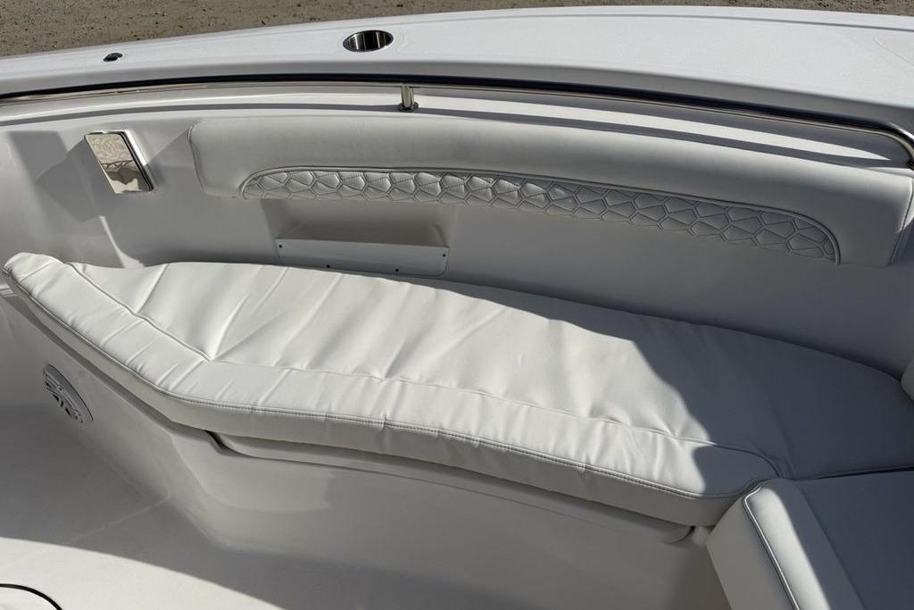 2026 Tidewater 232 LXF boat interior with white cushioned seating and elegant stitching.
