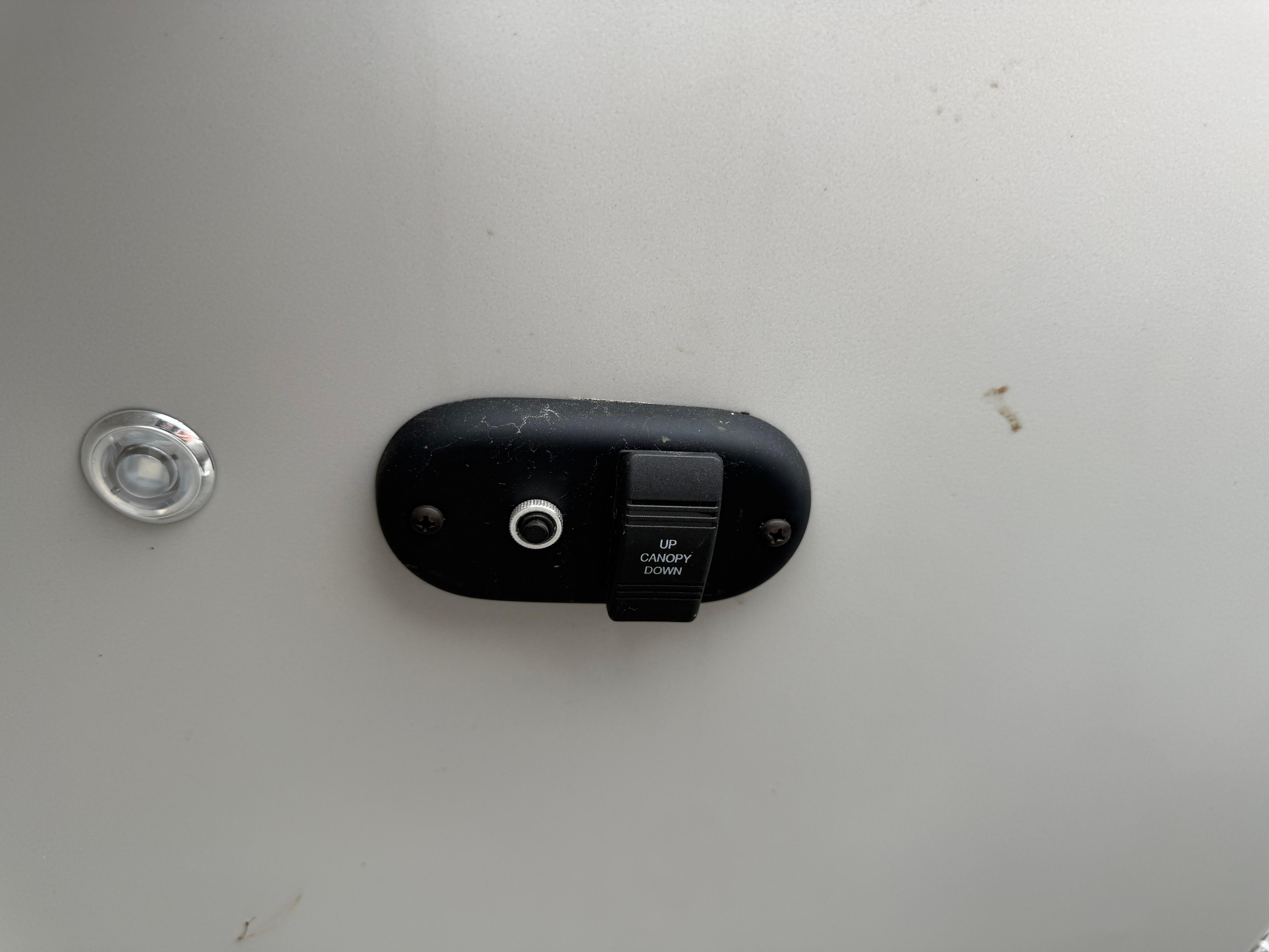 Switch panel on 2023 Godfrey Sweetwater boat for canopy control.