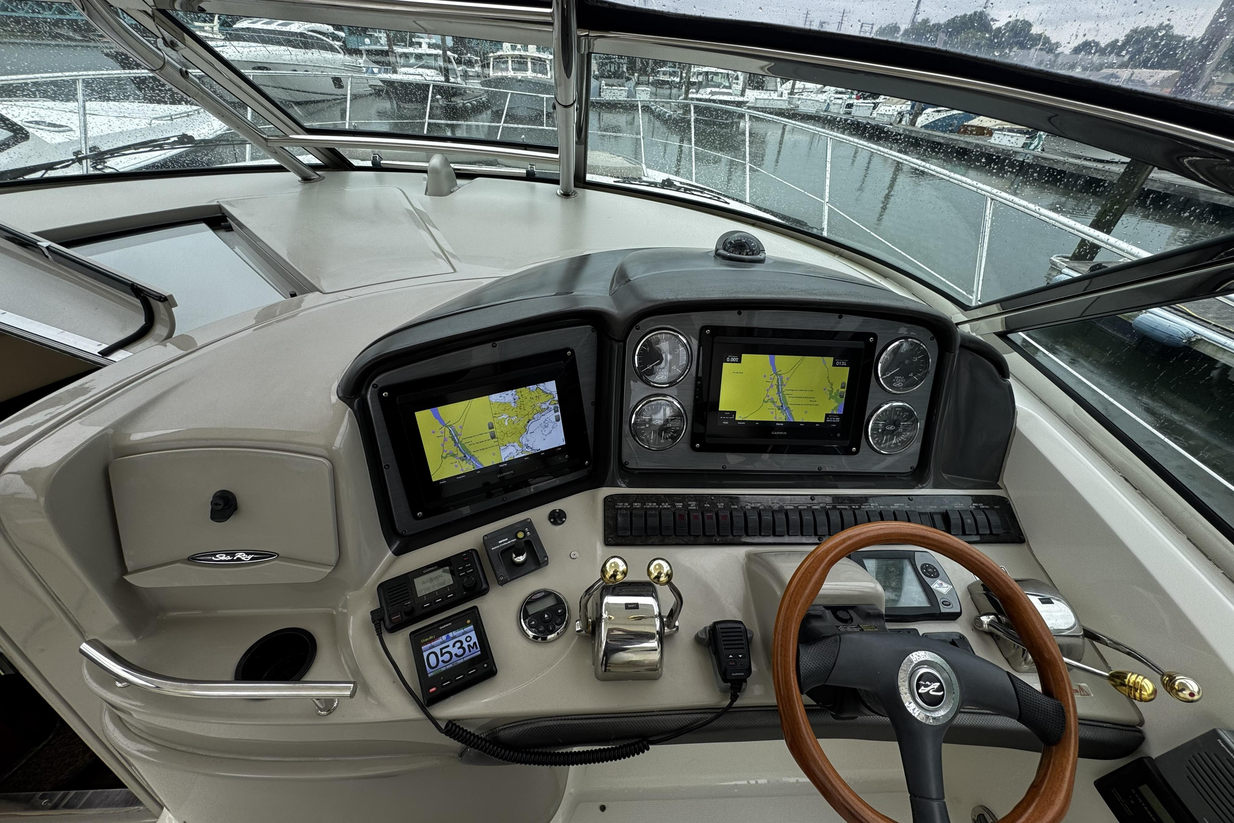 2006 Sea Ray 40 Sundancer helm with navigation screens and controls, docked in a marina.