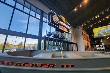 2026 Tracker Grizzly 10 Jon boat displayed in a showroom with large windows and signage.