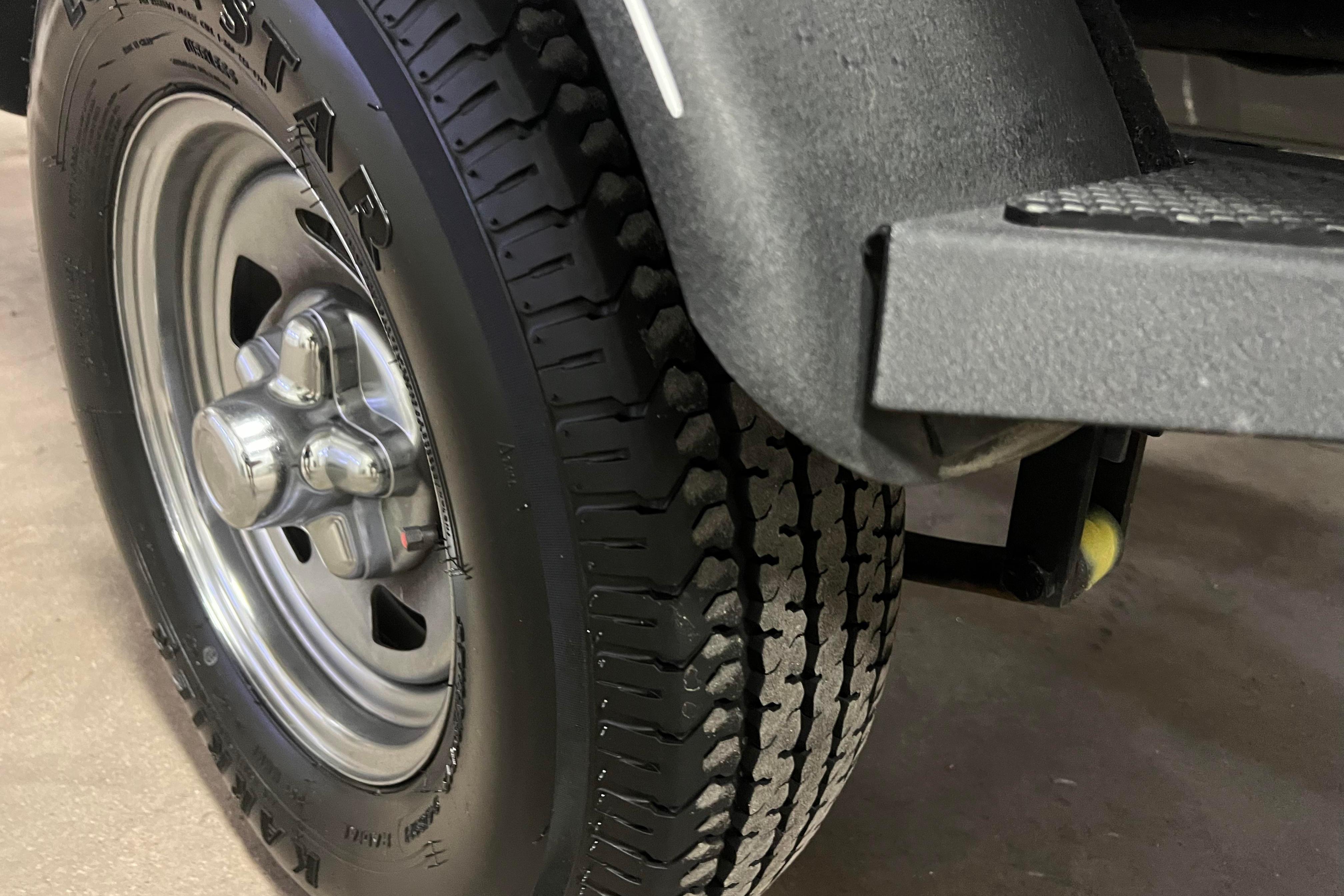Close-up of a 2022 Tracker Pro Guide V-16 WT trailer tire and wheel.