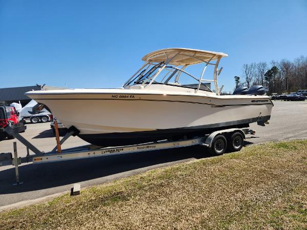 2015 Grady-White Freedom 275 boat on trailer, parked outdoors under clear blue sky.