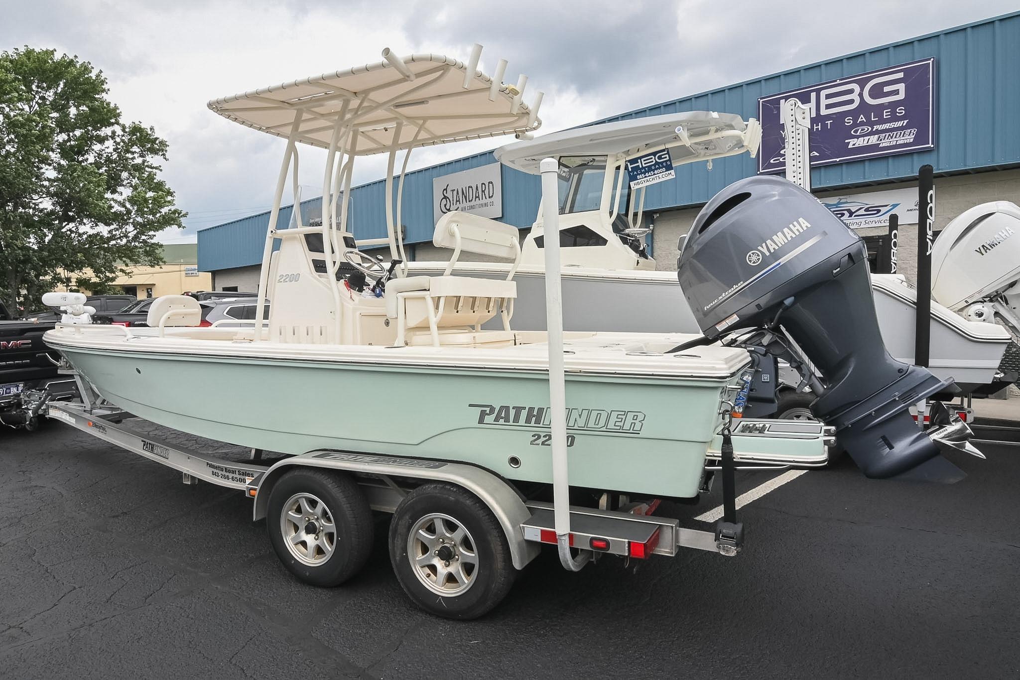 2021 Pathfinder 2200 TRS boat with Yamaha engine on trailer at dealership.
