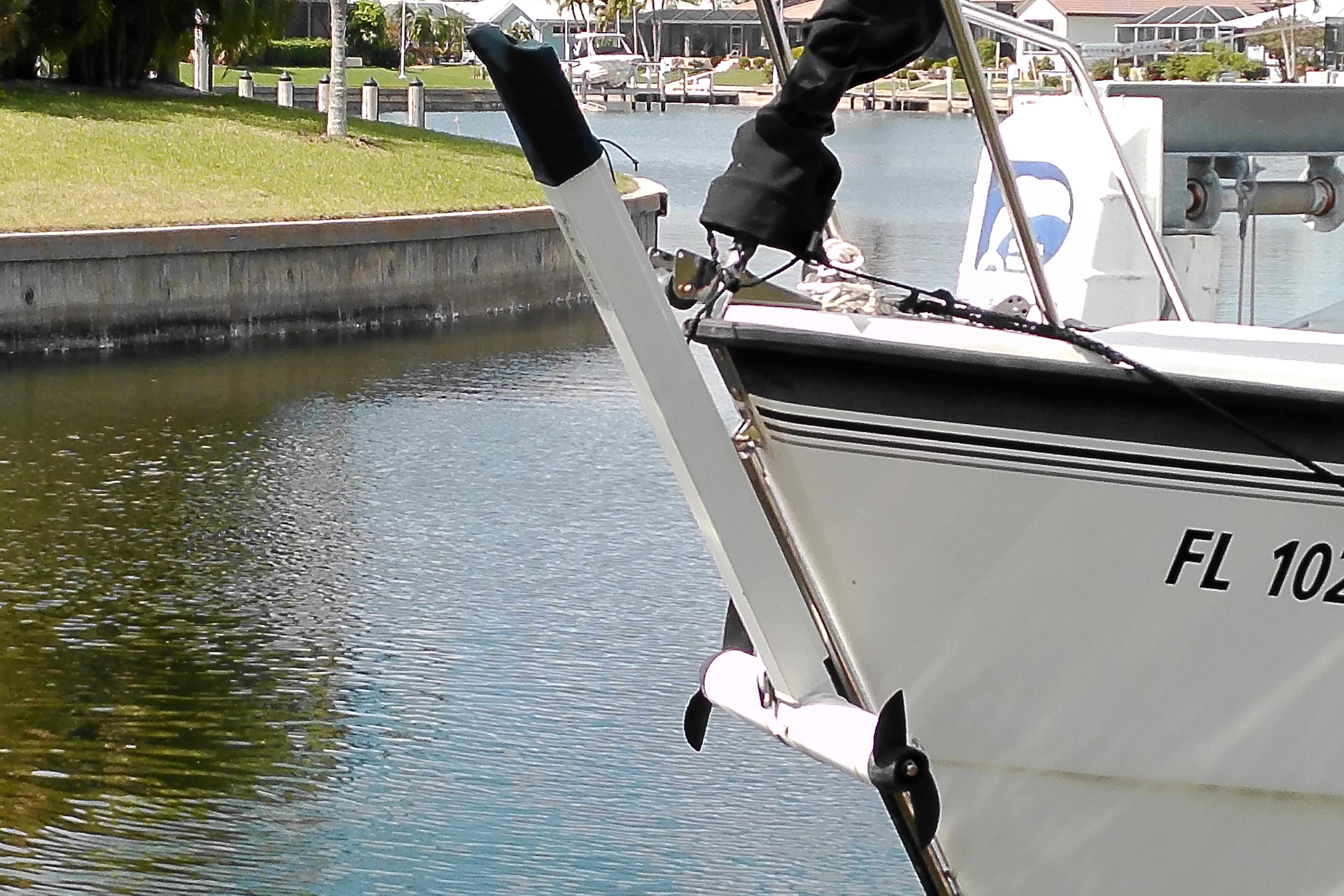 2011 MacGregor 26M sailboat docked in a calm marina setting.