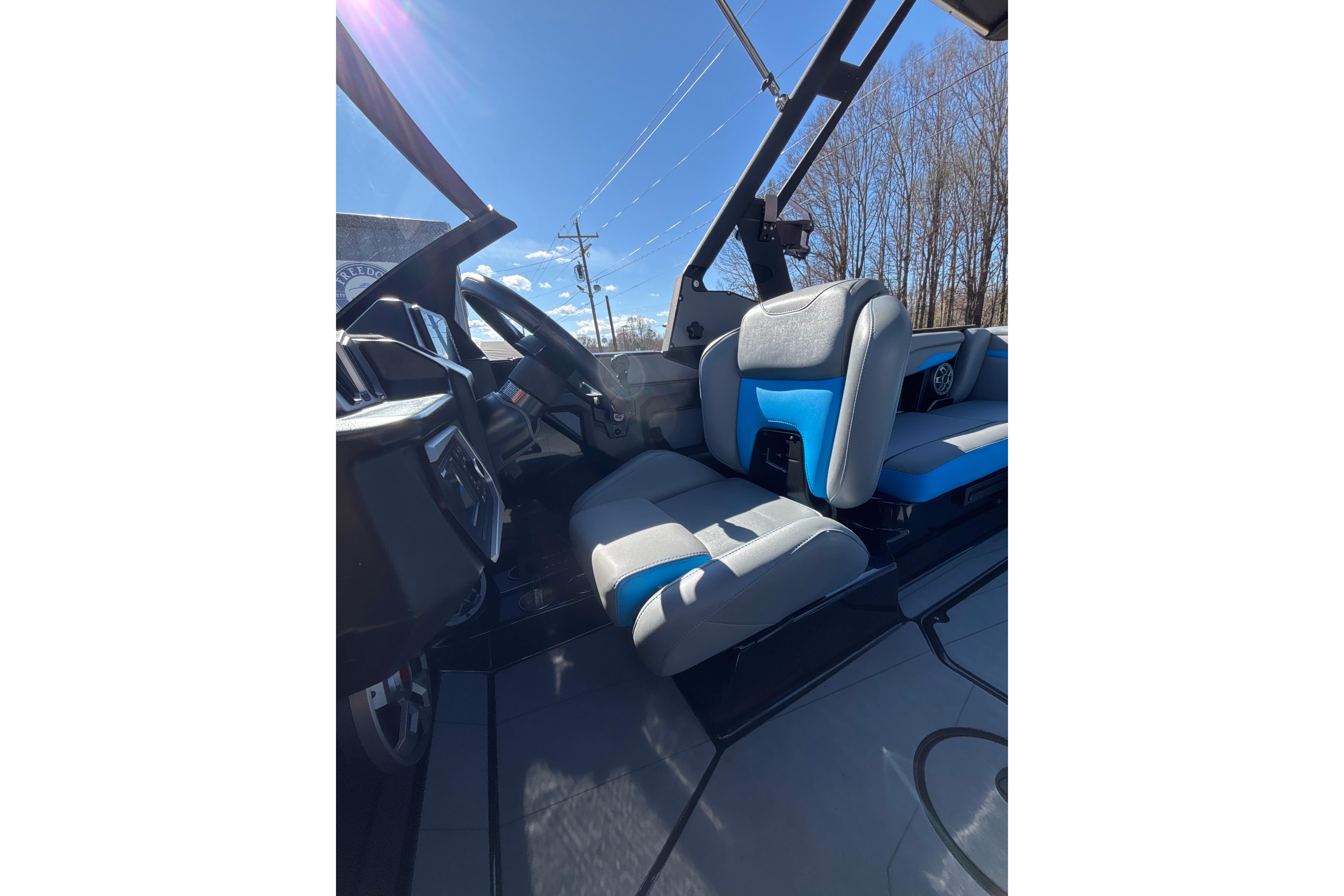 2023 Axis T220 boat interior with blue and gray seating under clear sky.