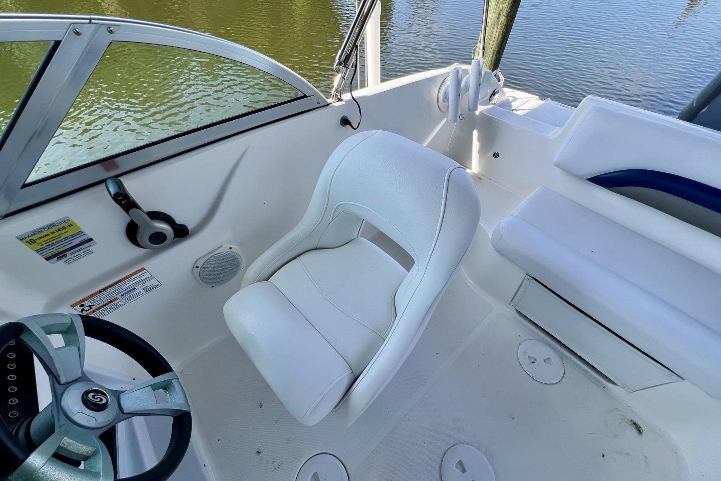 2013 Hurricane SunDeck 187 OB boat interior with white seating and steering wheel.